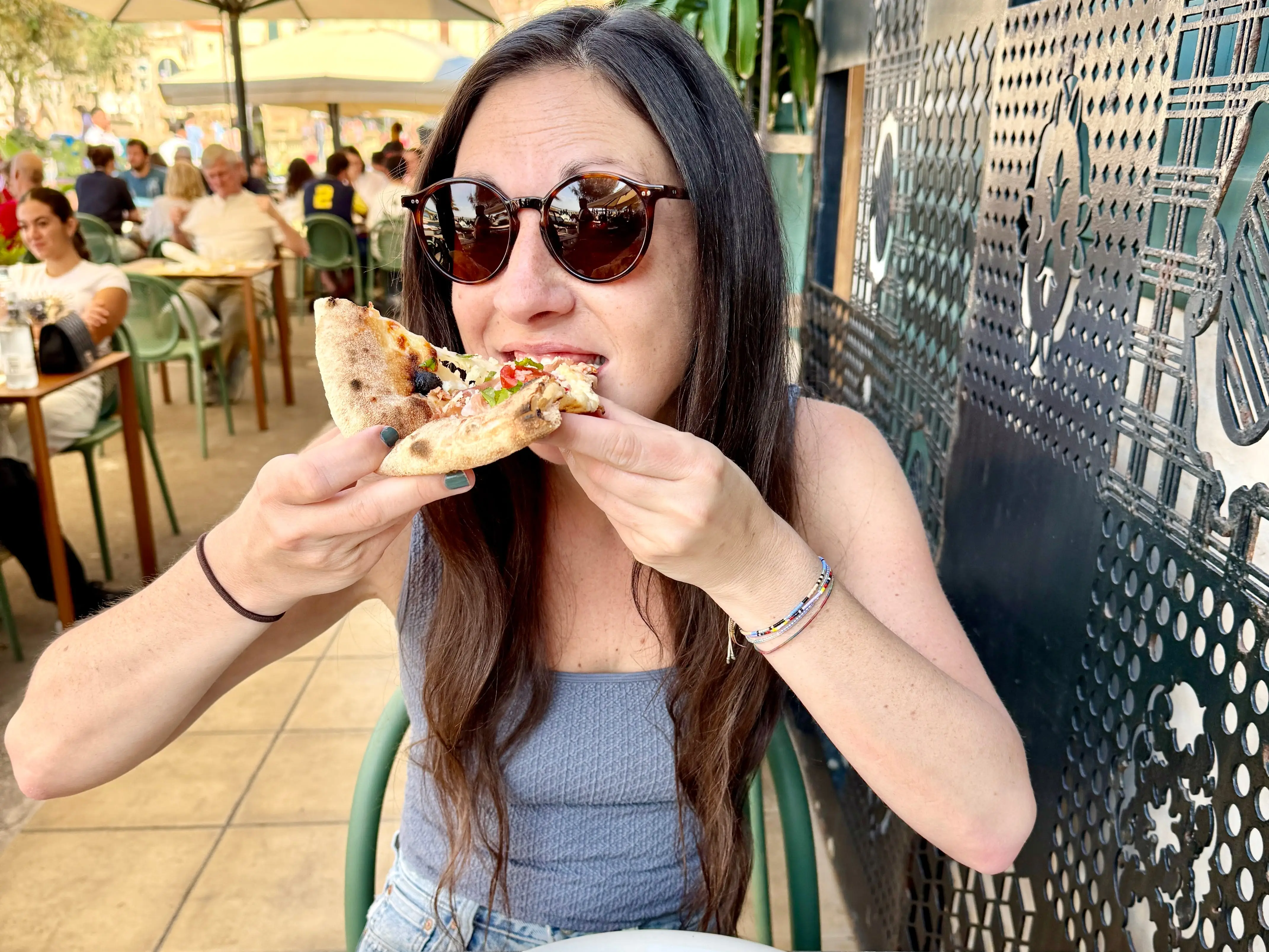 Woman eating slice of pizza in Sicily