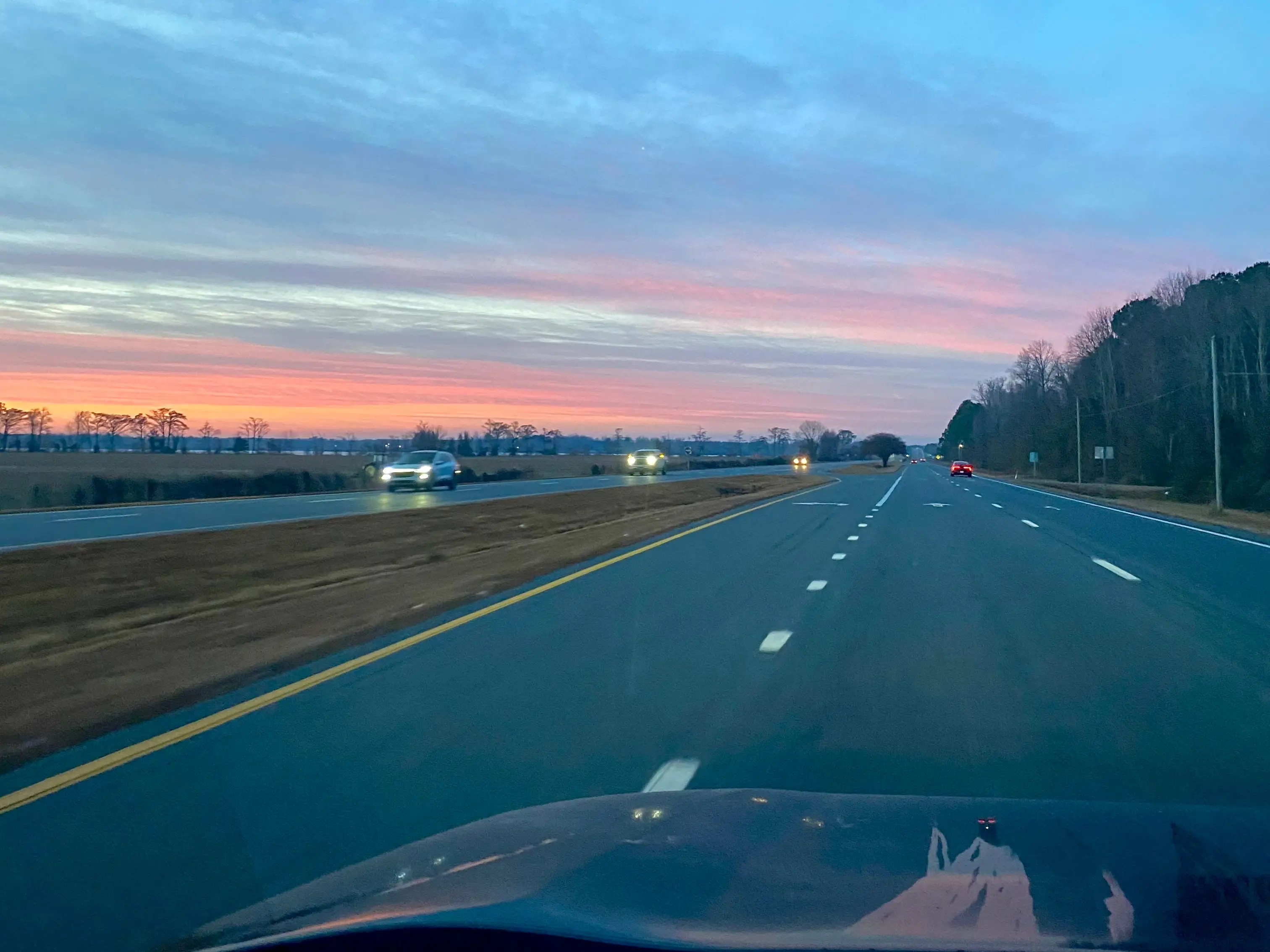 The view of a sunset from a car driving along a road in North Carolina.