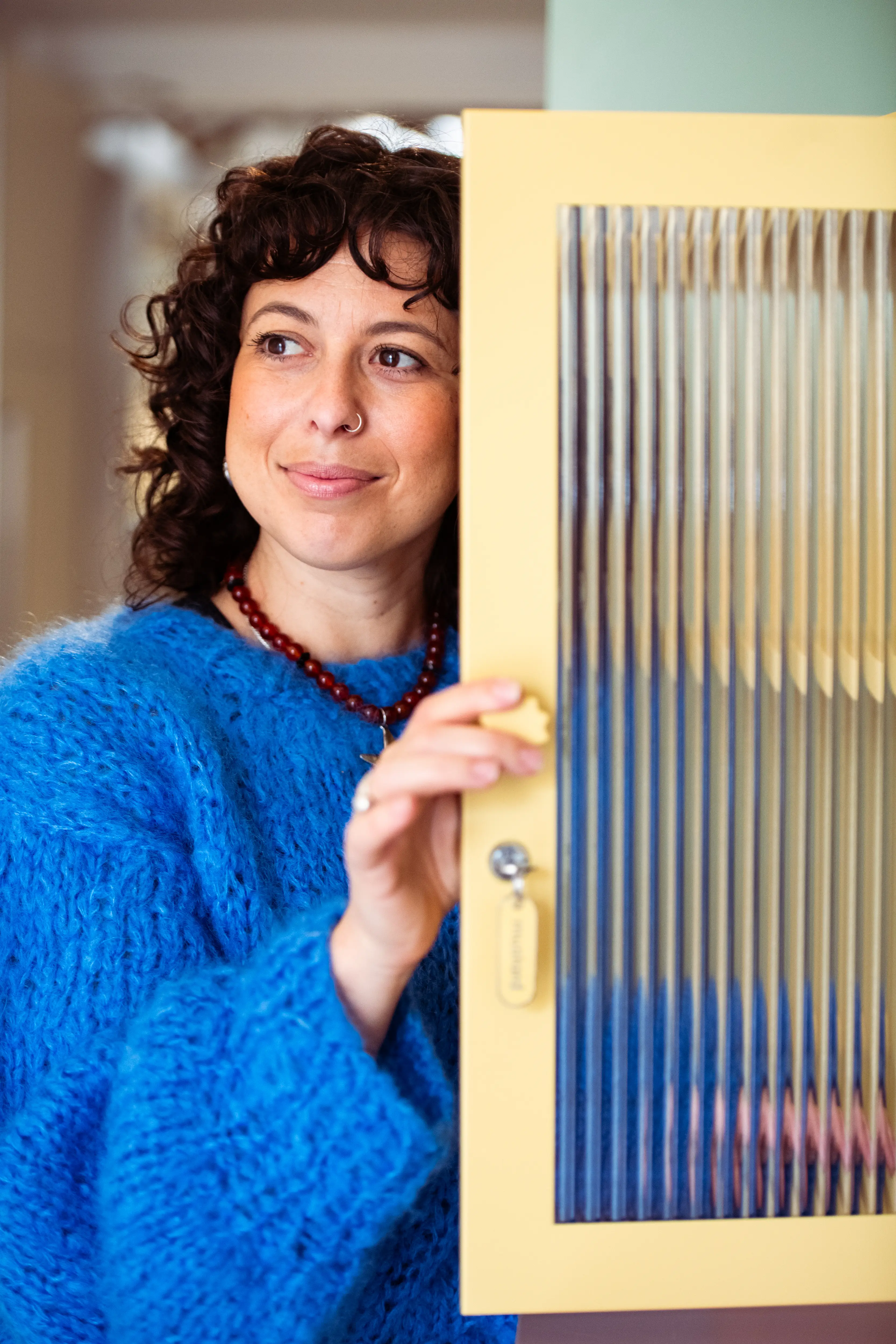 Becca Stern, co-founder of Mustard Made, peers out from one of her lockers.