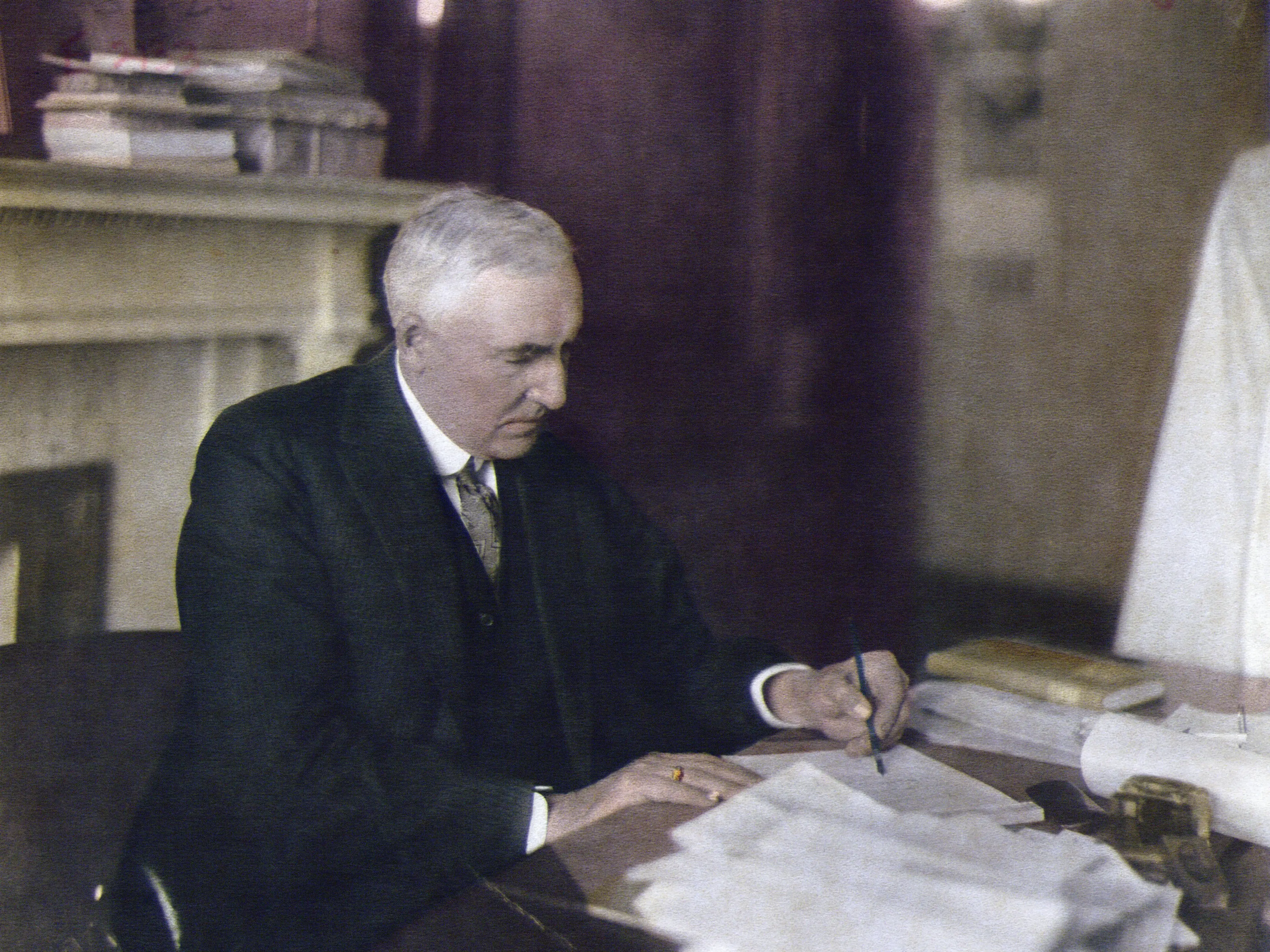 Warren G. Harding writing at his desk