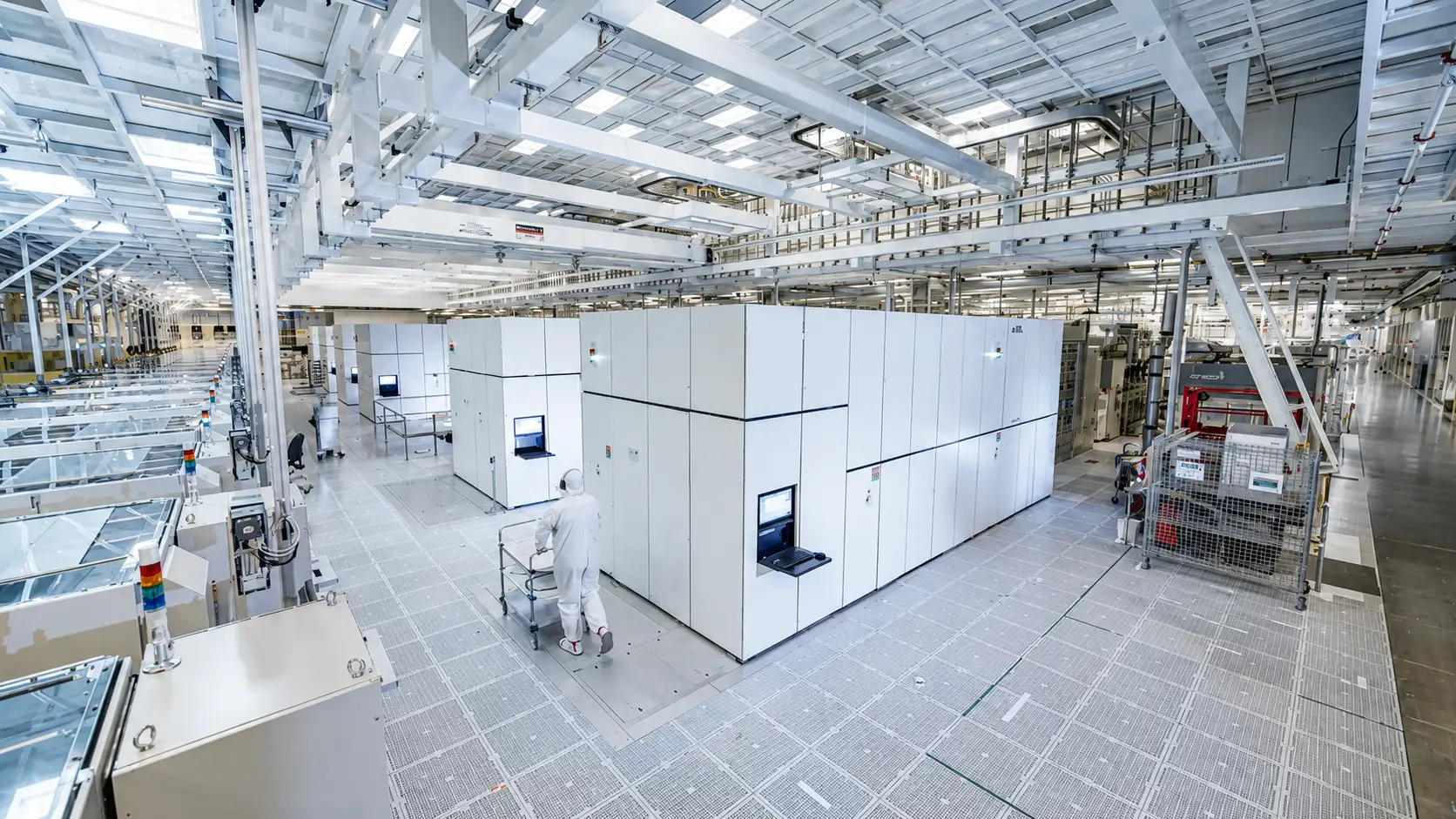 An Intel fabrication plant worker walks past a row of billion-dollar tools.