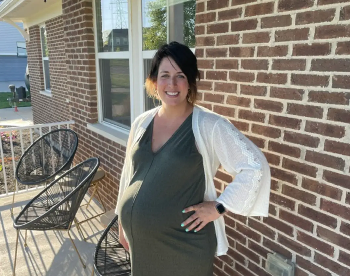 Pregnant woman standing on porch