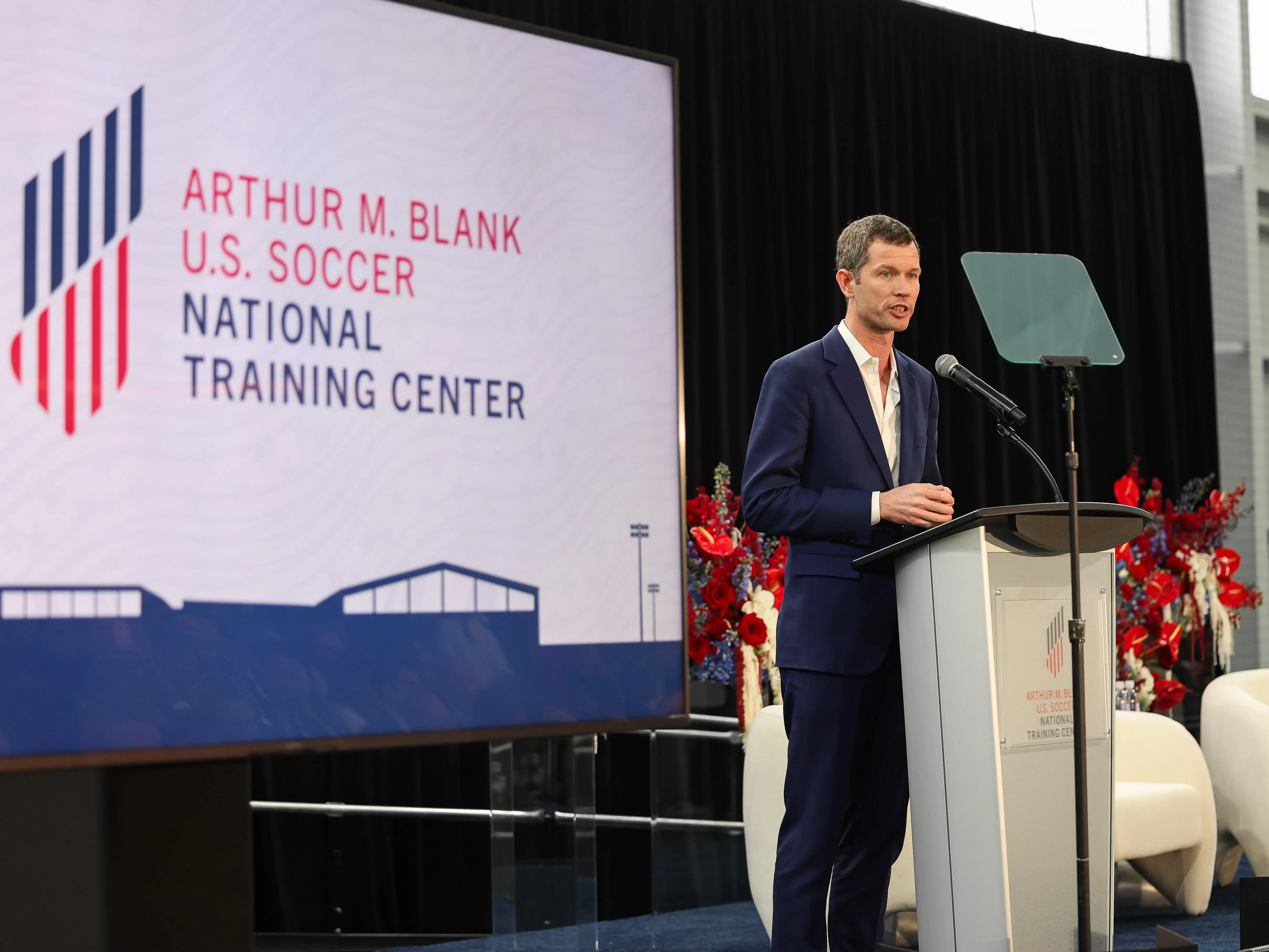 US Soccer CEO JT Batson speaks at a podium