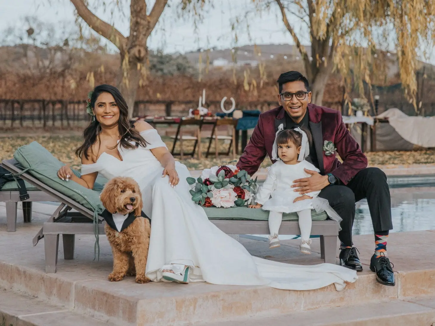 Family and dog posing renewing vows by a swimming pool.