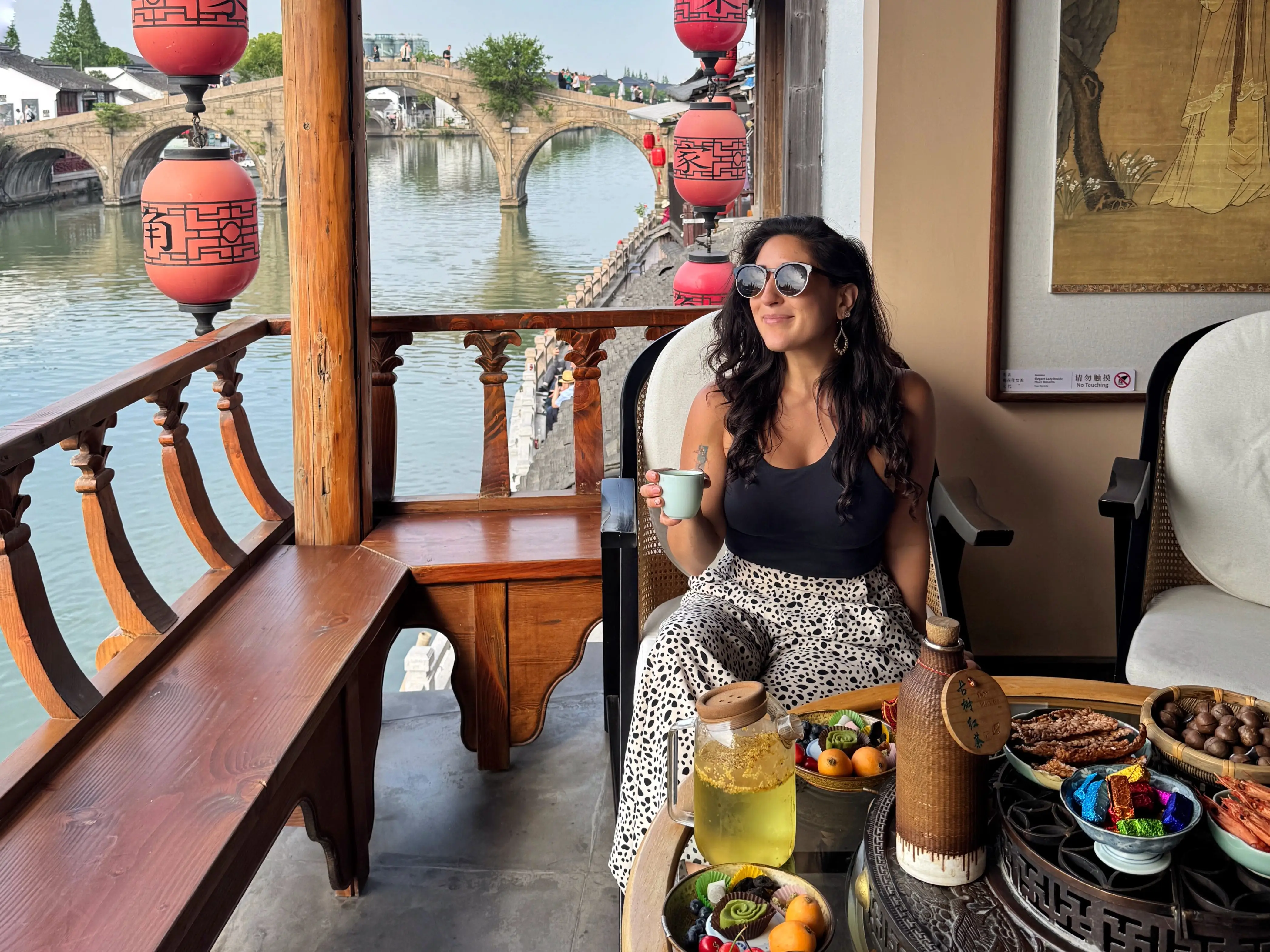A woman drinking tea by the water in China.
