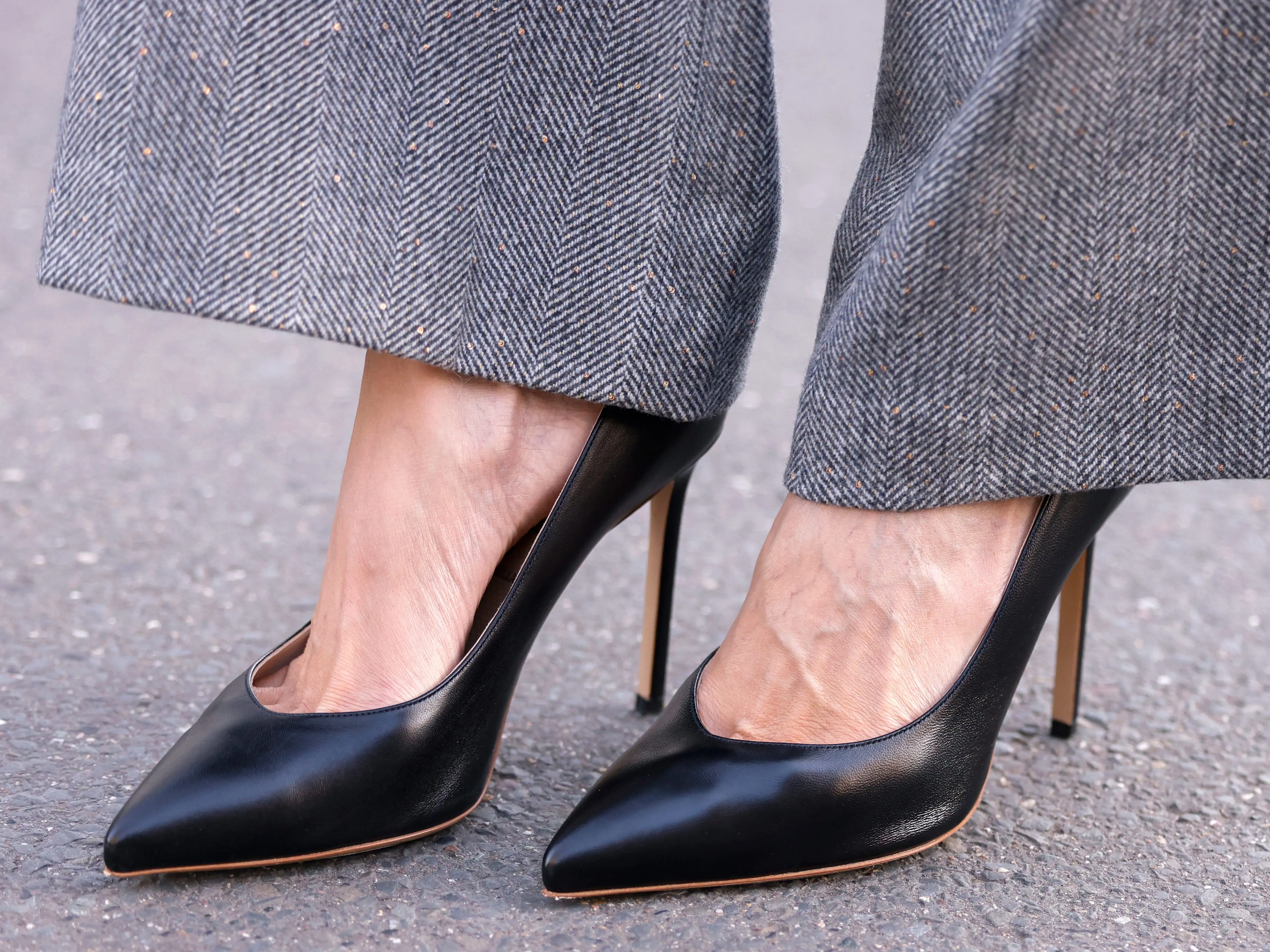 A woman wearing a pair of black stilettos with trousers.