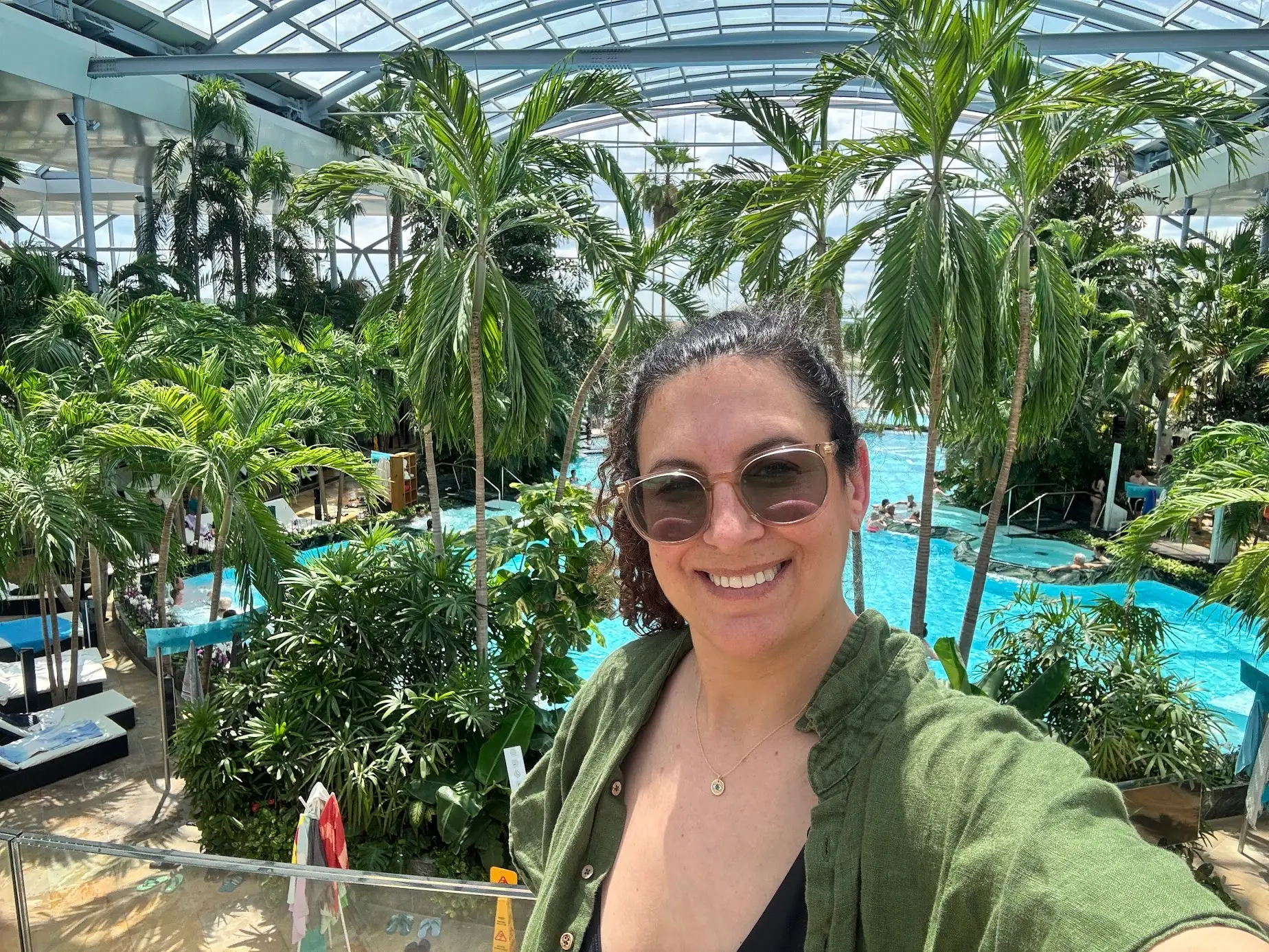 The author in front of a pool and palm trees.