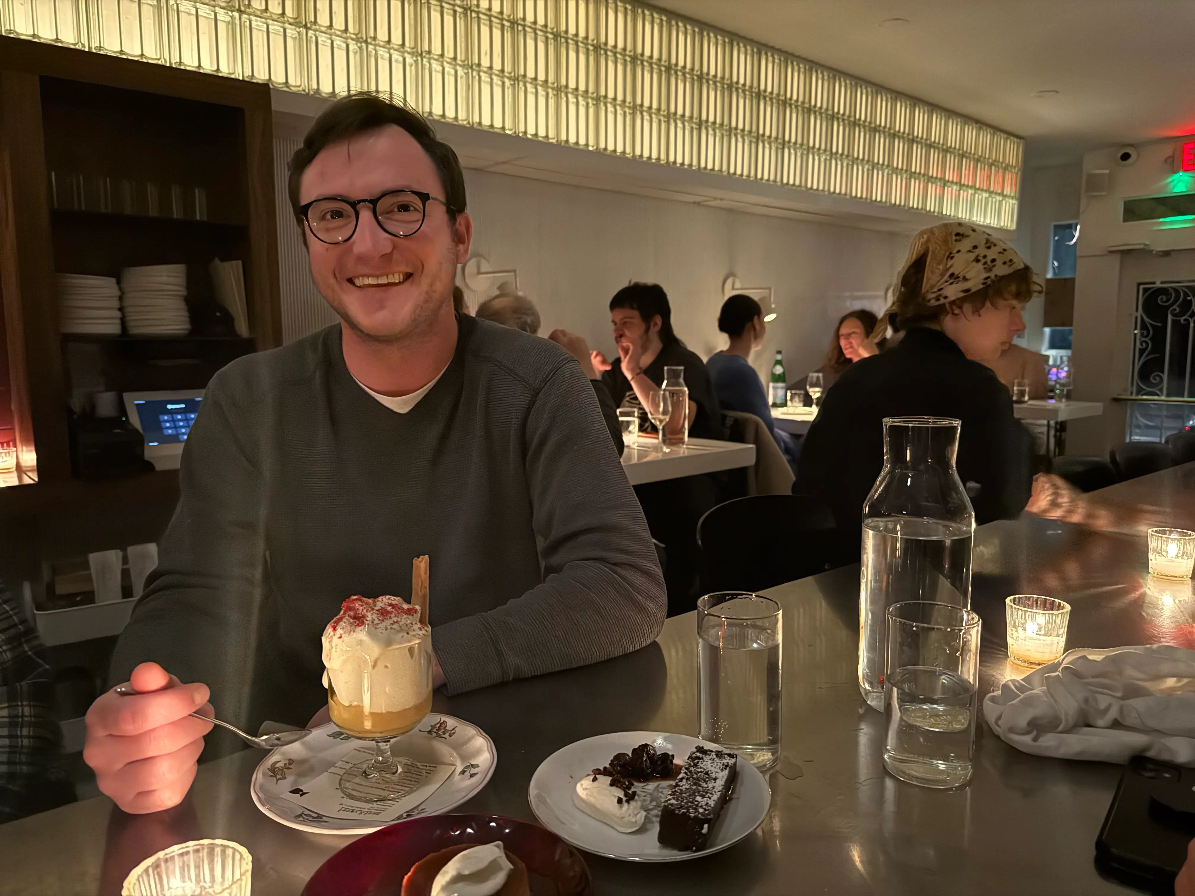Man smiling with dessert in a restaurant