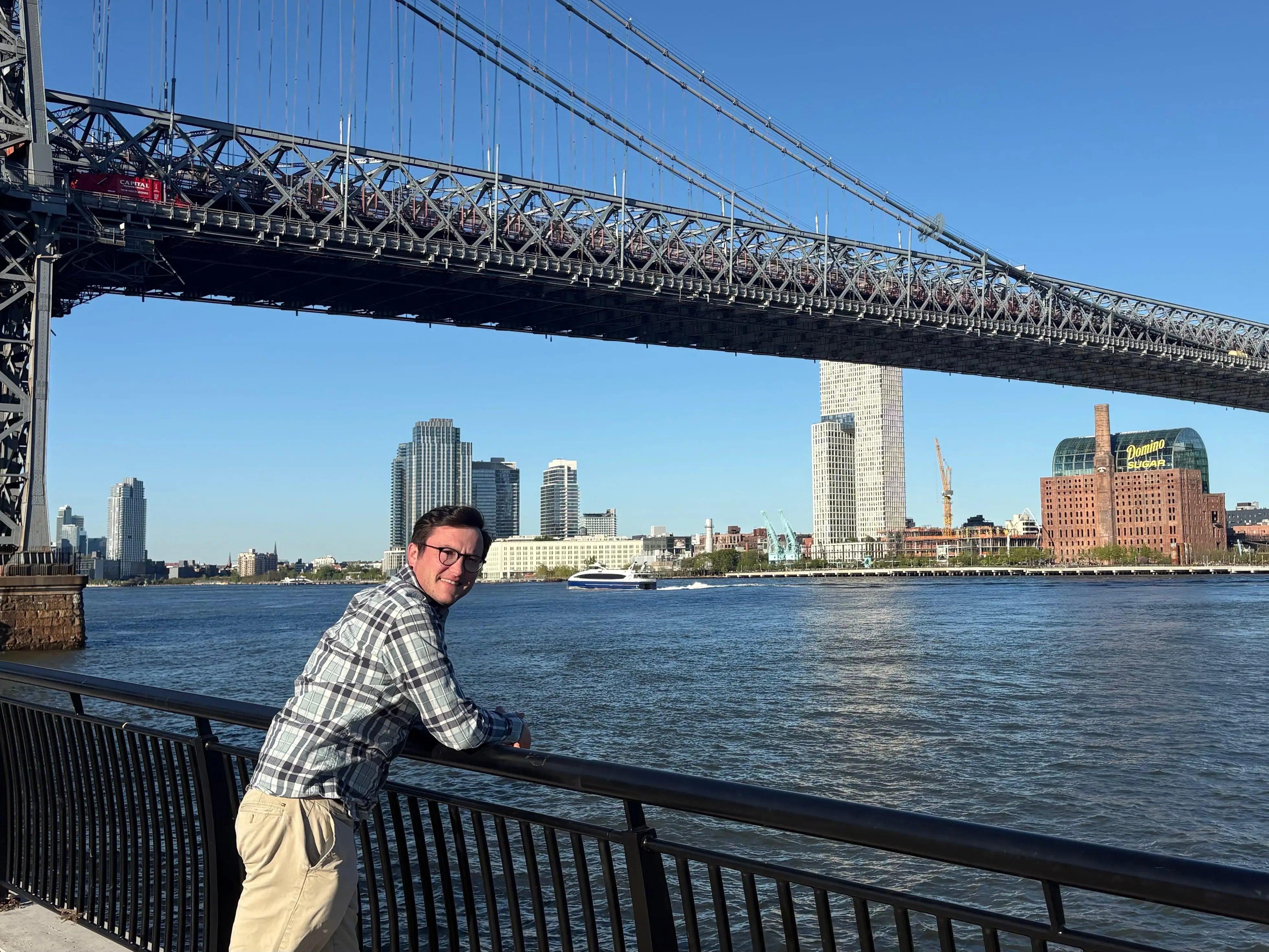 Man leaning near water by bridge in New York City