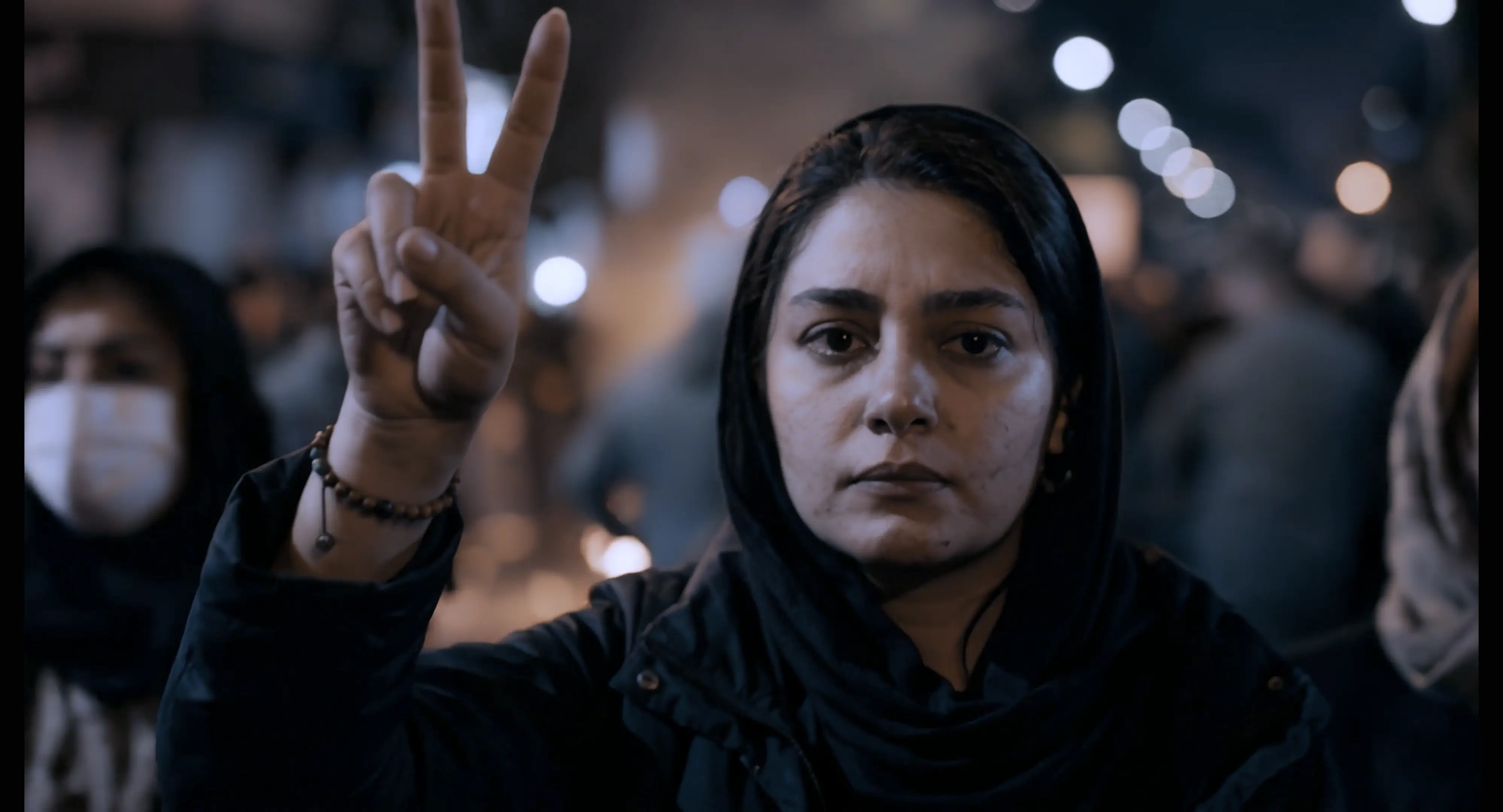 A woman makes the peace sign at a protest.