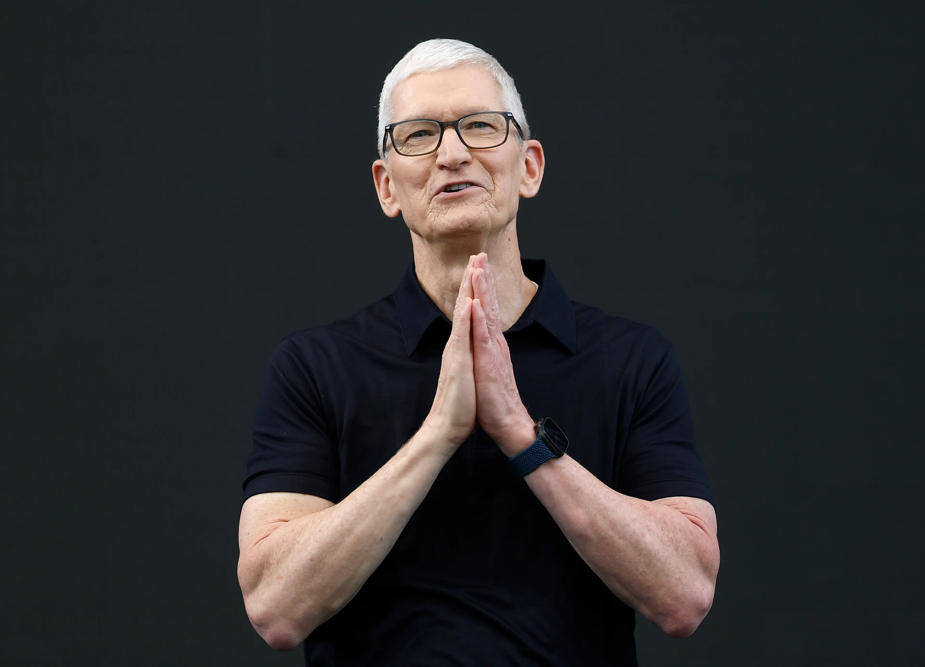 Tim Cook's hands are pressed together as he talks onstage during the 2026 Apple Worldwide Developers Conference.