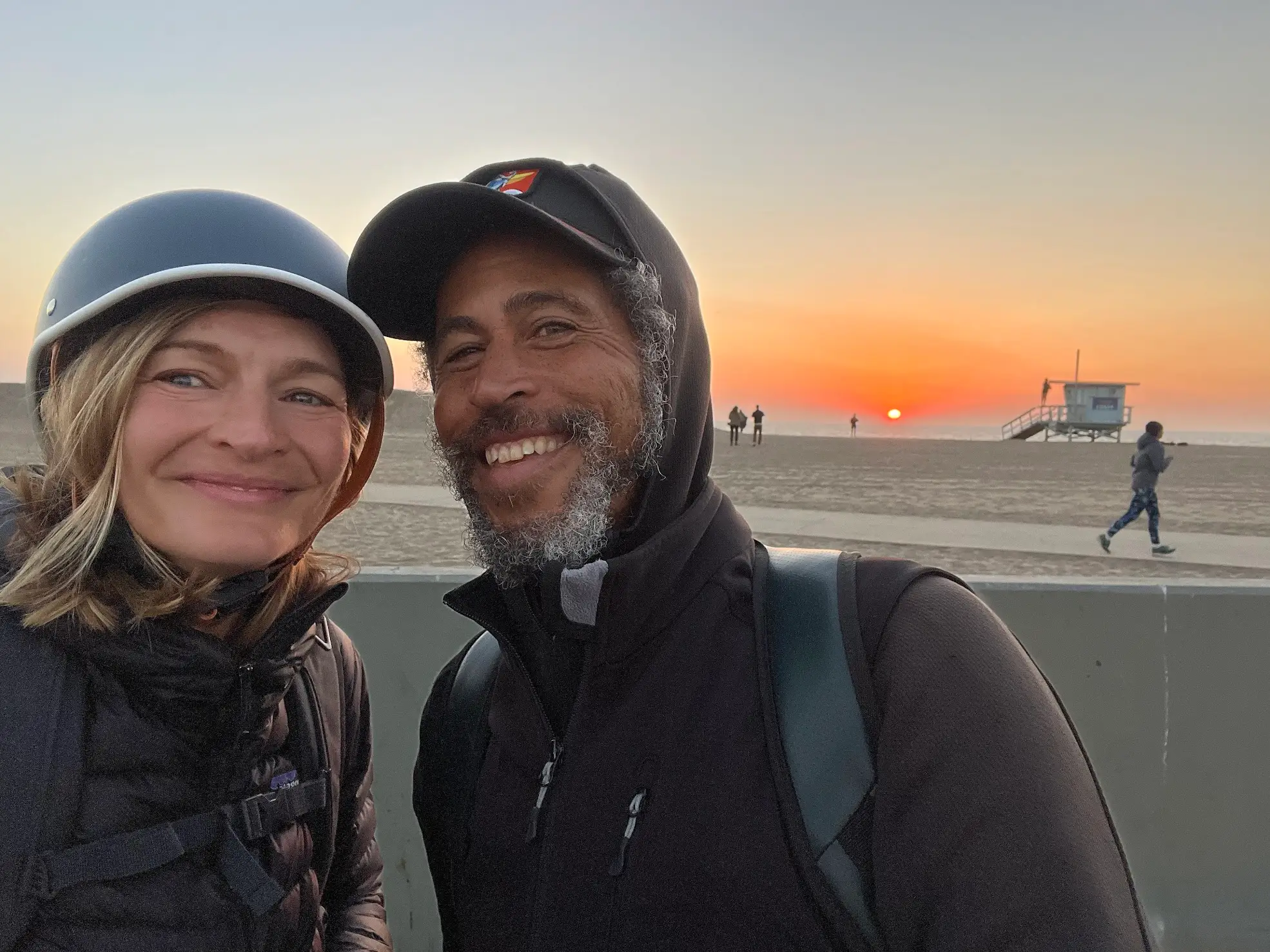Man and woman in hats smiling on beach