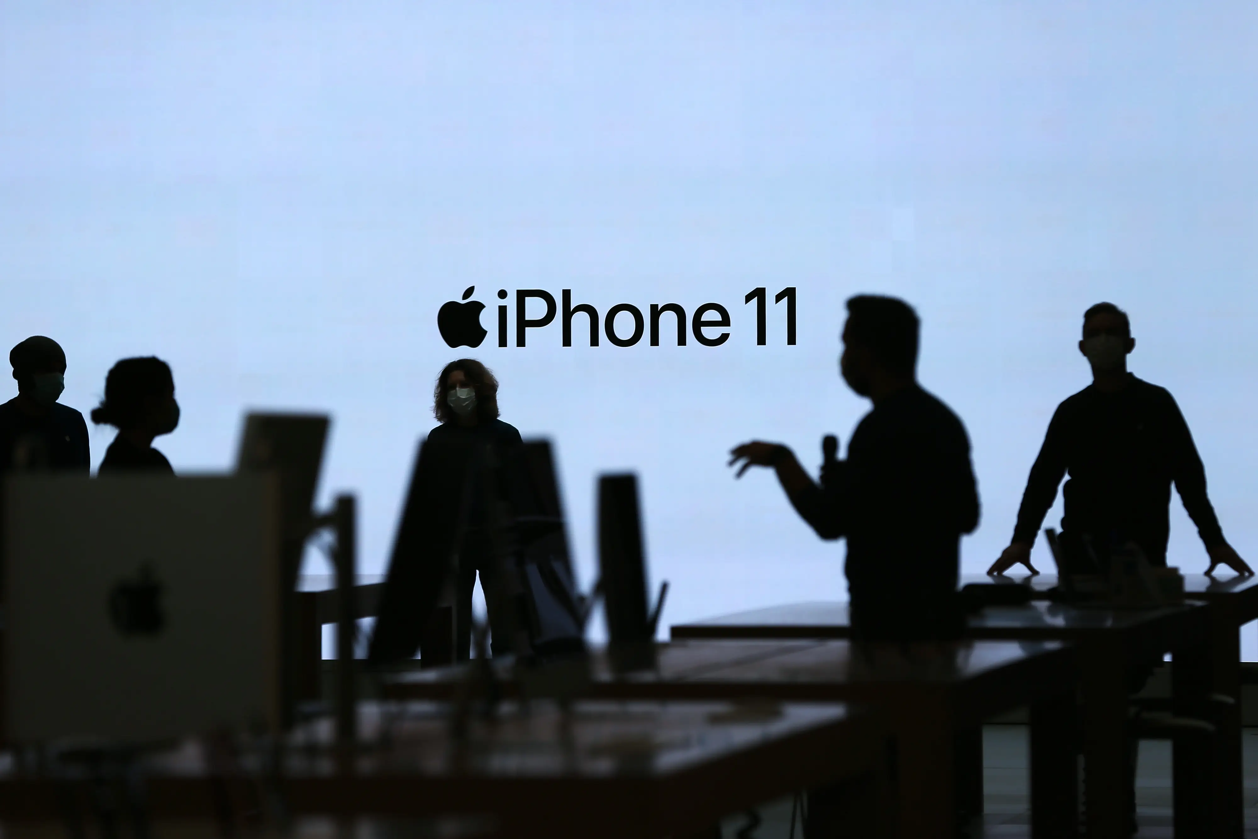 Several people stand in front of a white screen that says 