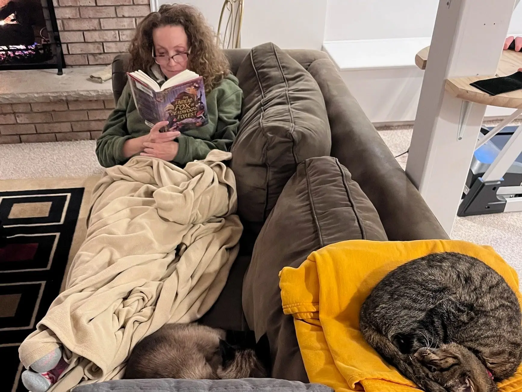 Woman reading book with cats