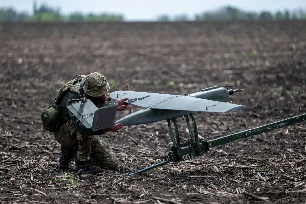 A Ukrainain soldier prepares a mid-range drone for launch on a rail catapult.