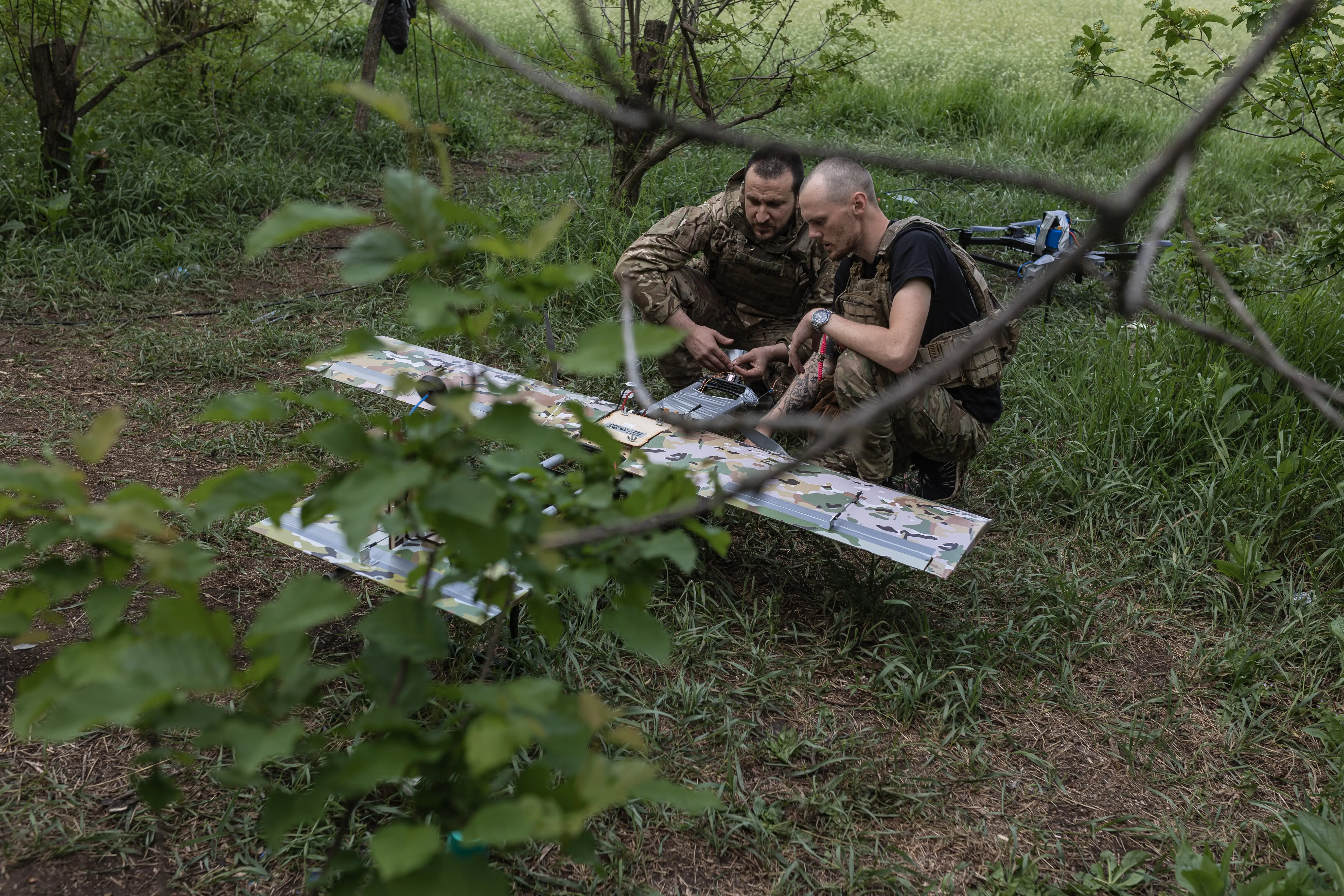 Two Ukrainian troops prepare a Blyskavka attack drone.