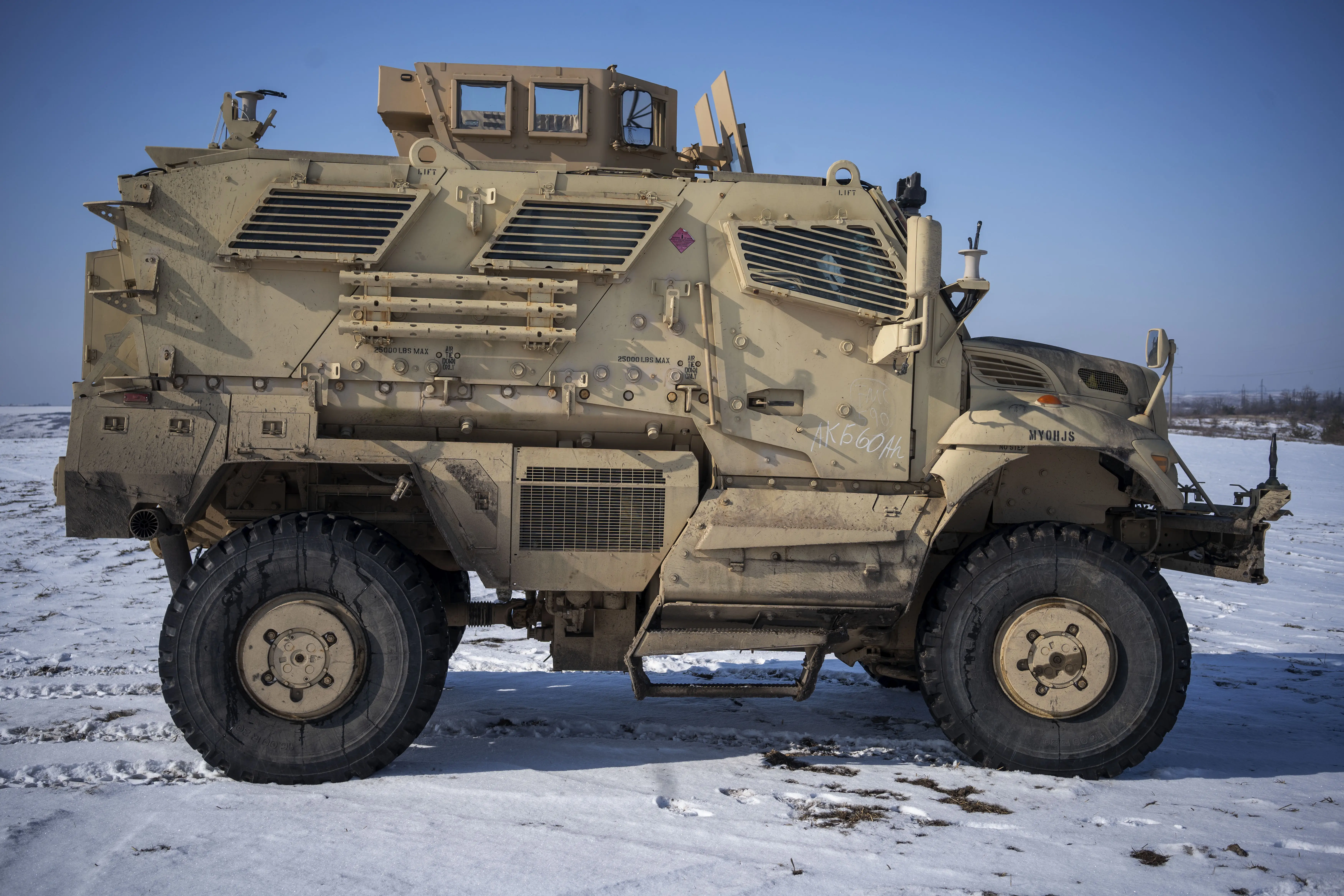 An International M1224 MaxxPro sits on a snow-covered field.