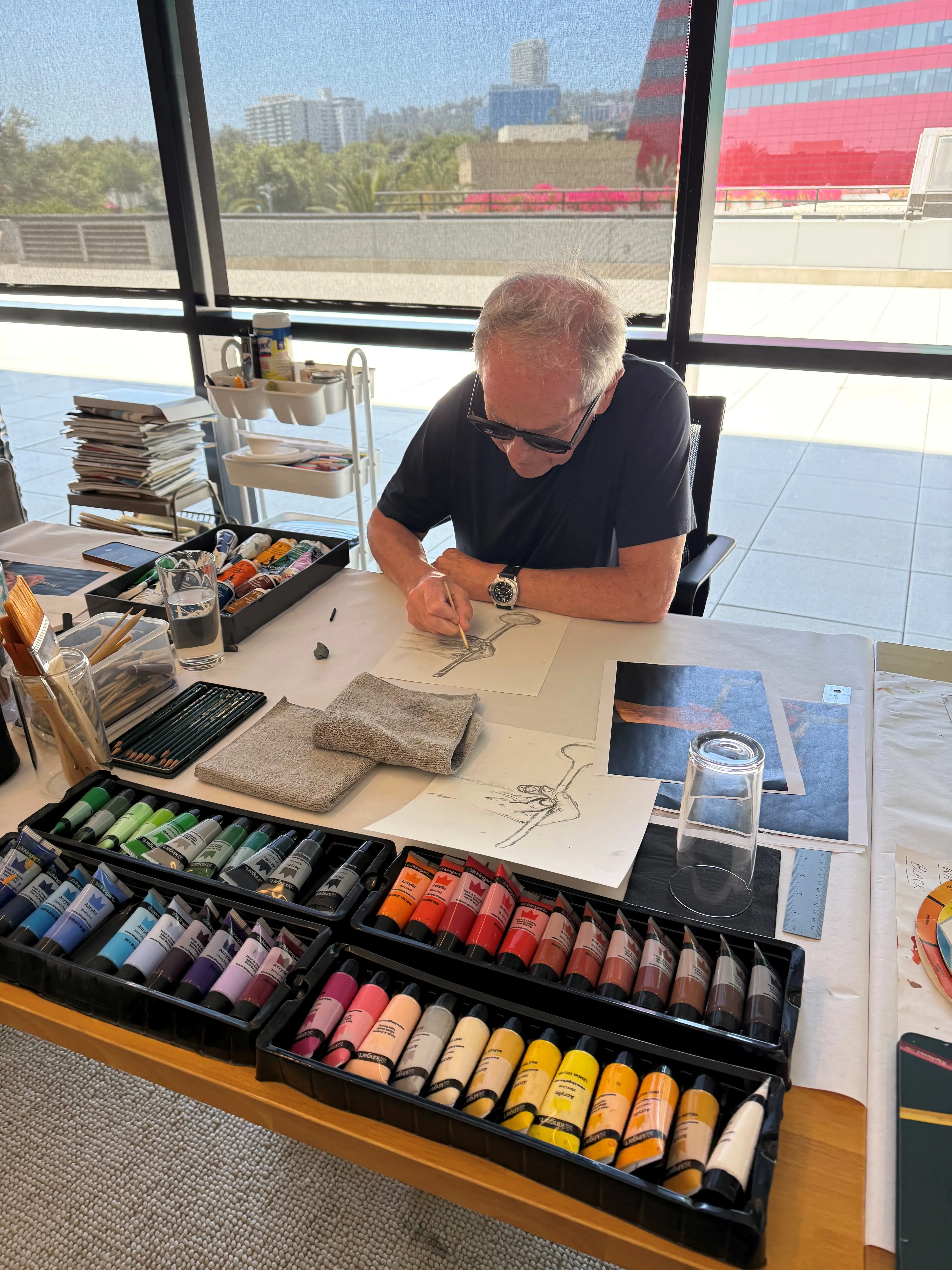 Wolfgang Puck in his office drawing on paper.
