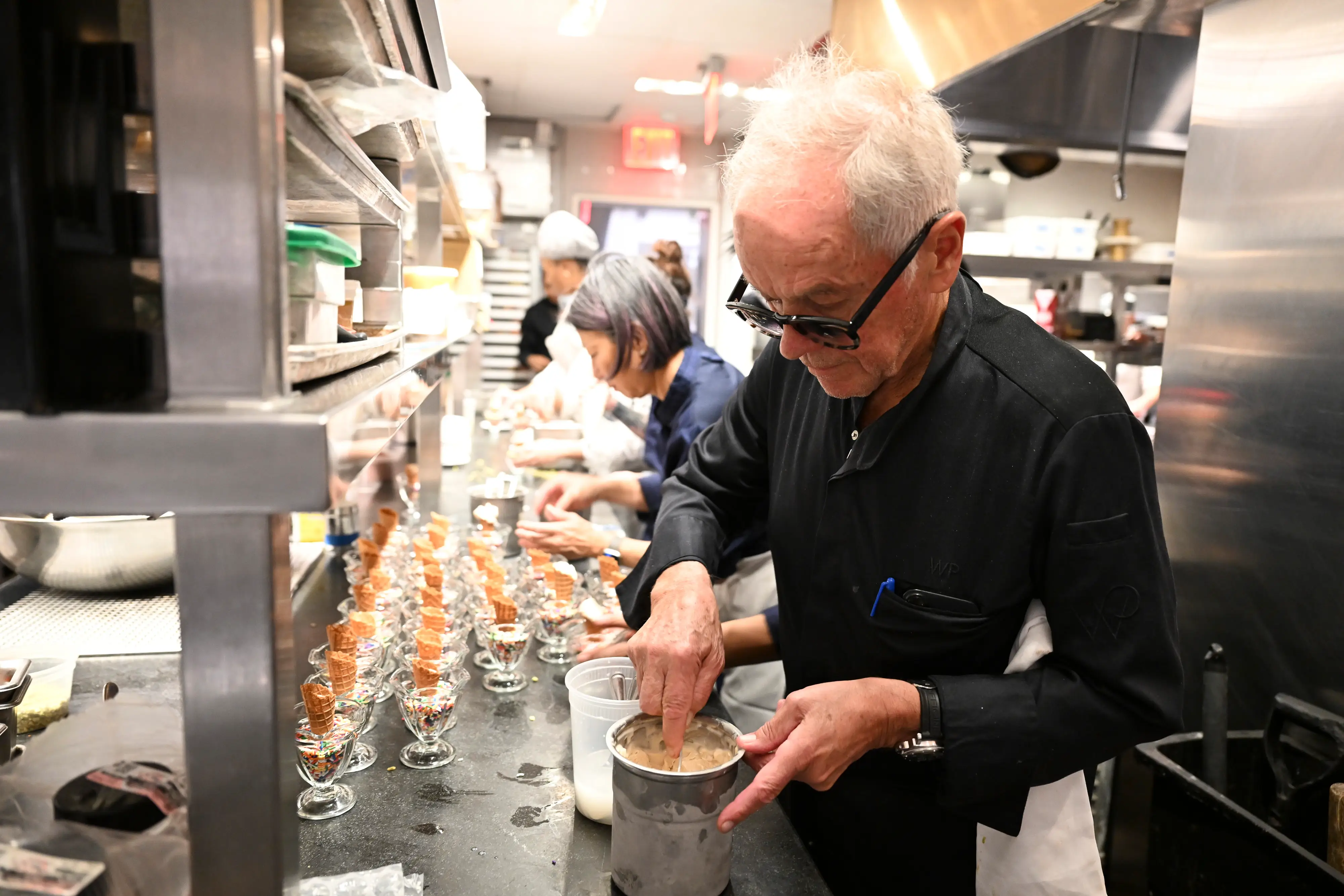 Chef Wolfgang Puck prepares dishes at the Food Network New York City Wine & Food Festival.