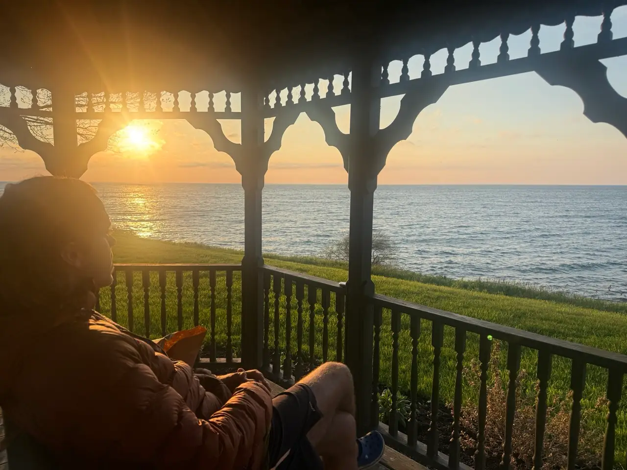 Man sitting on porch watching sunset at Golden Hill State Park