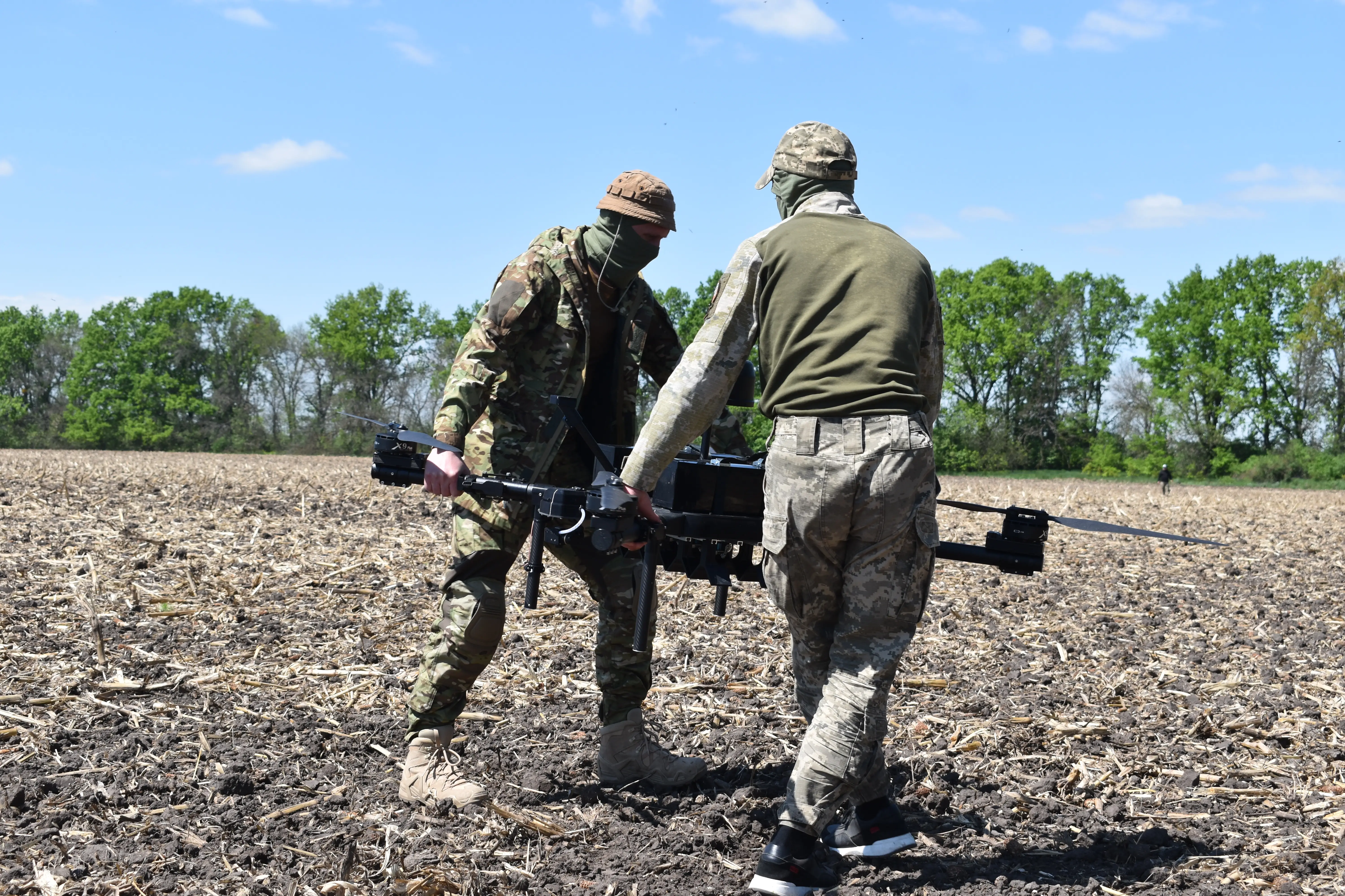 Ukrainians carry a Perun drone before launching it at a training range.