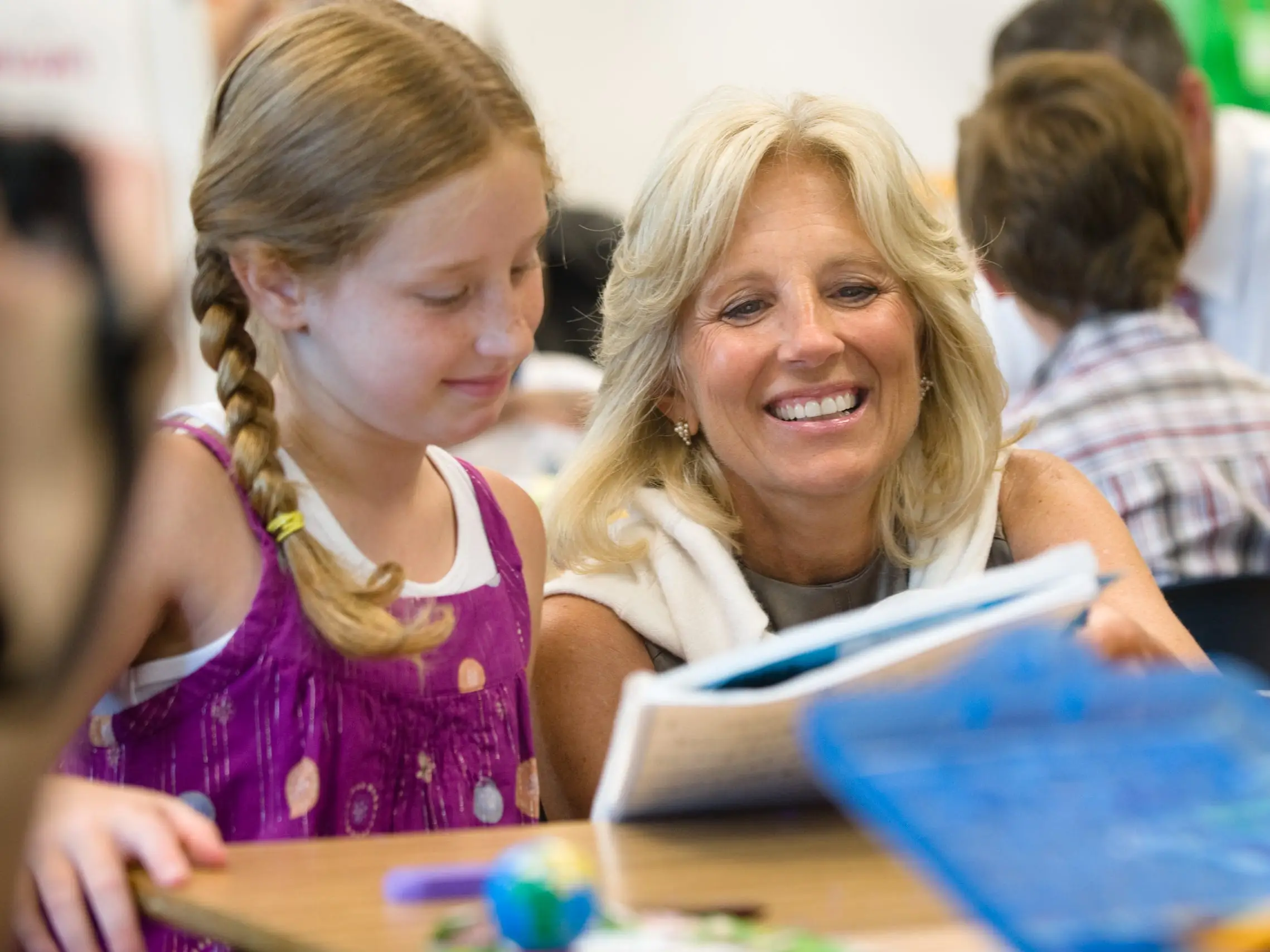 Jill Biden shows a student a notebook