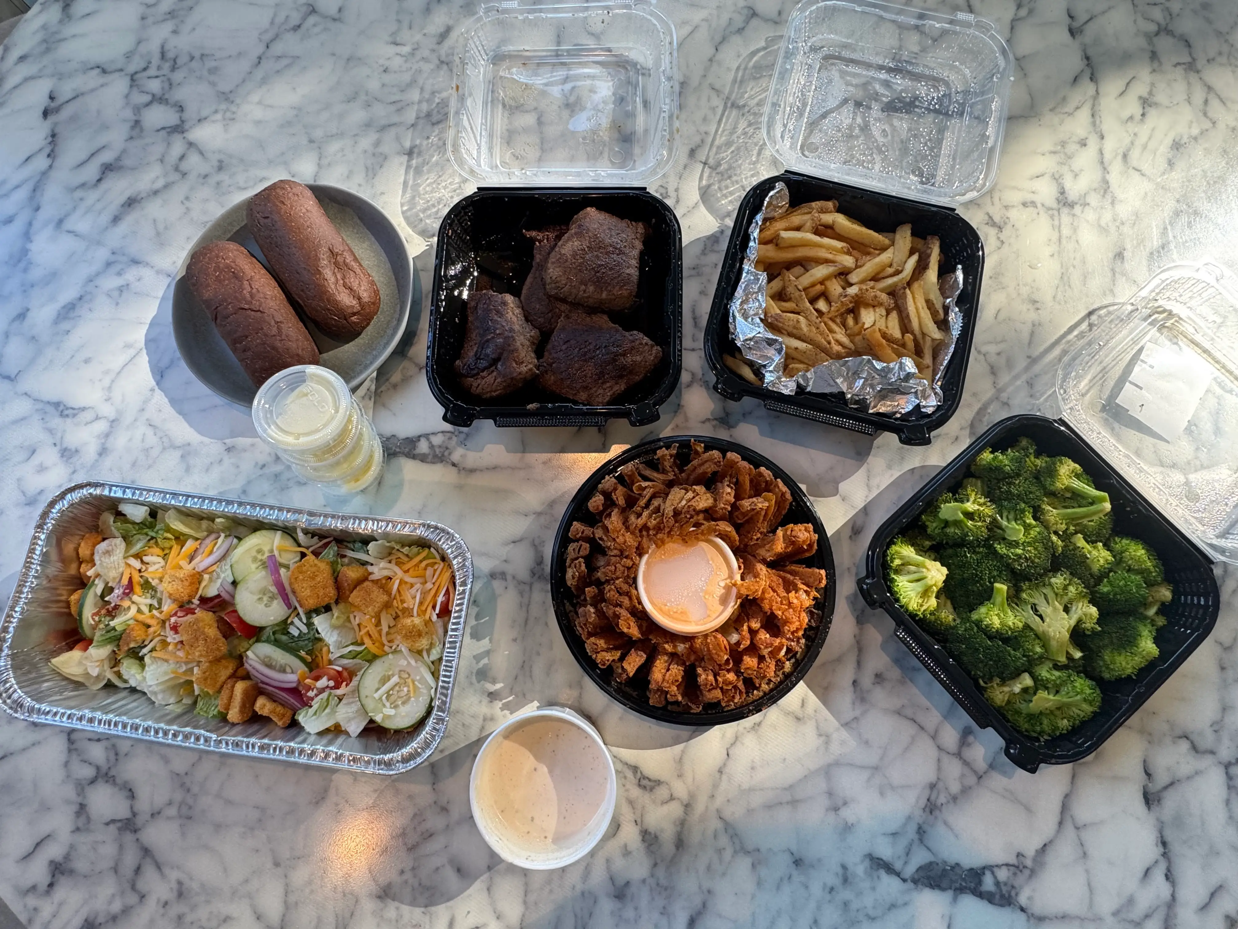 Aerial view of Containers of food from Outback Steakhouse on counter
