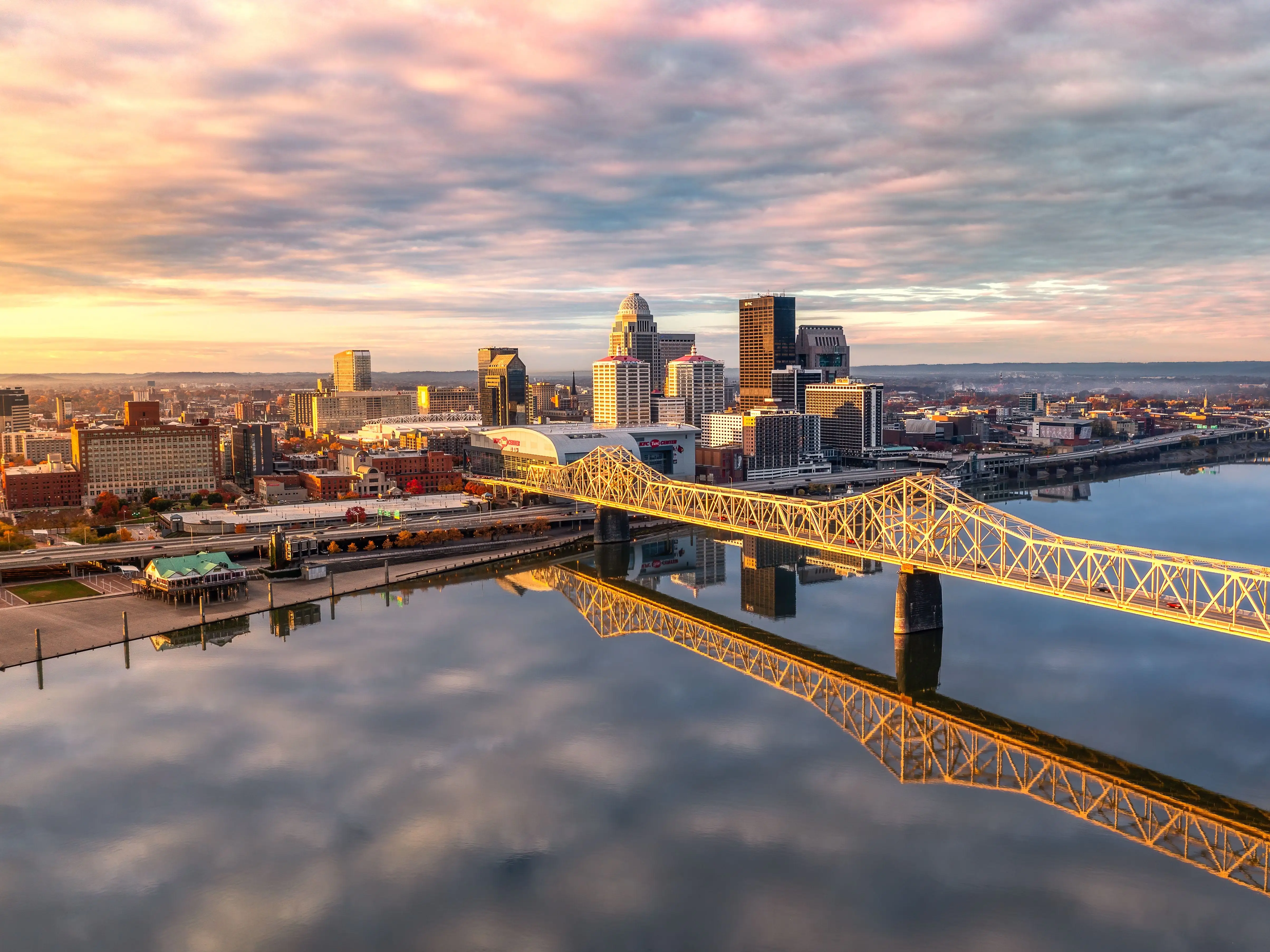 An aerial shot of the skyline of Louisville and the bridge at sunrise.