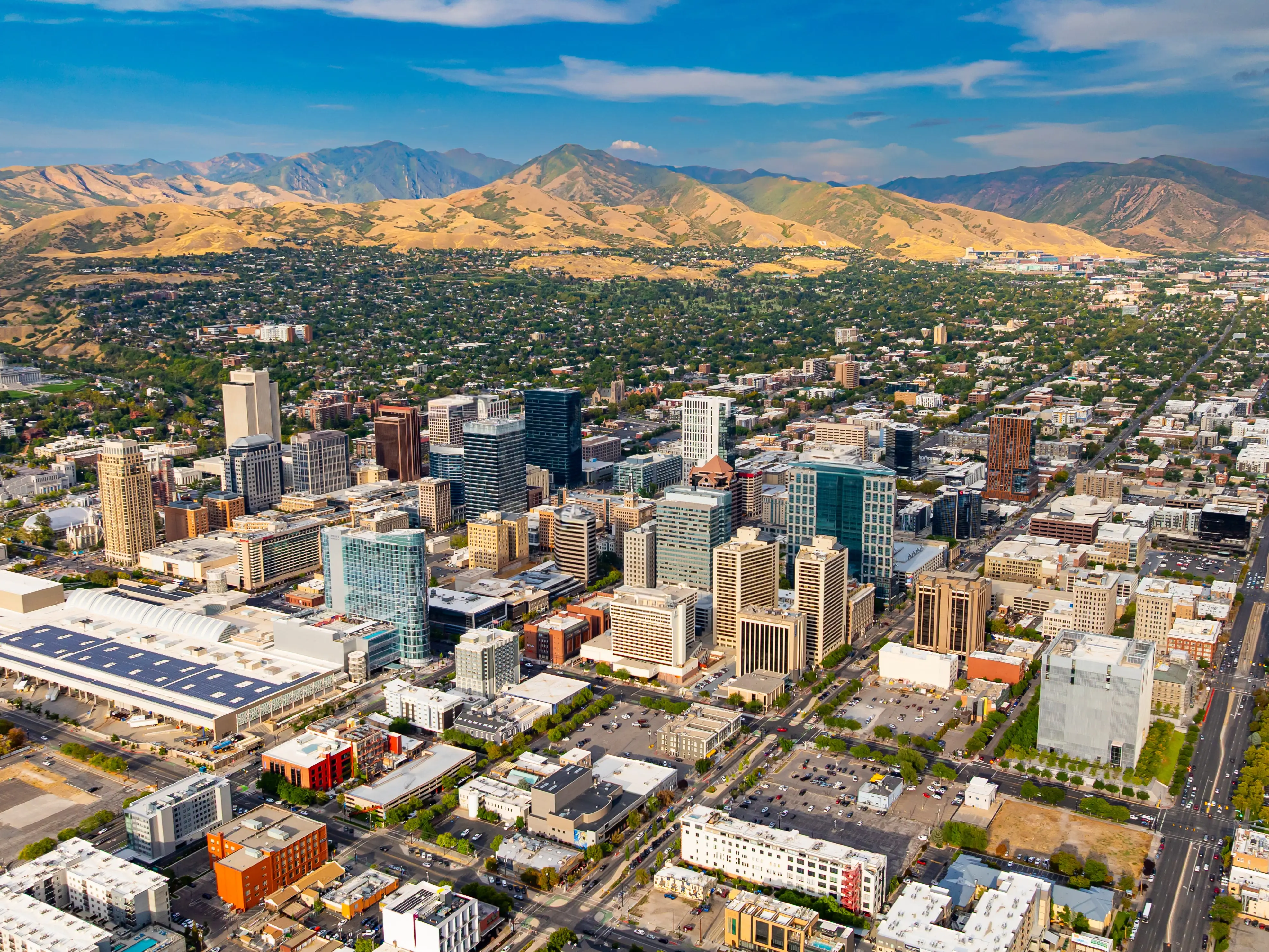 Downtown of Salt Lake City, Utah, USA. Green residential area scattered at backdrop at the foot of the mountains.