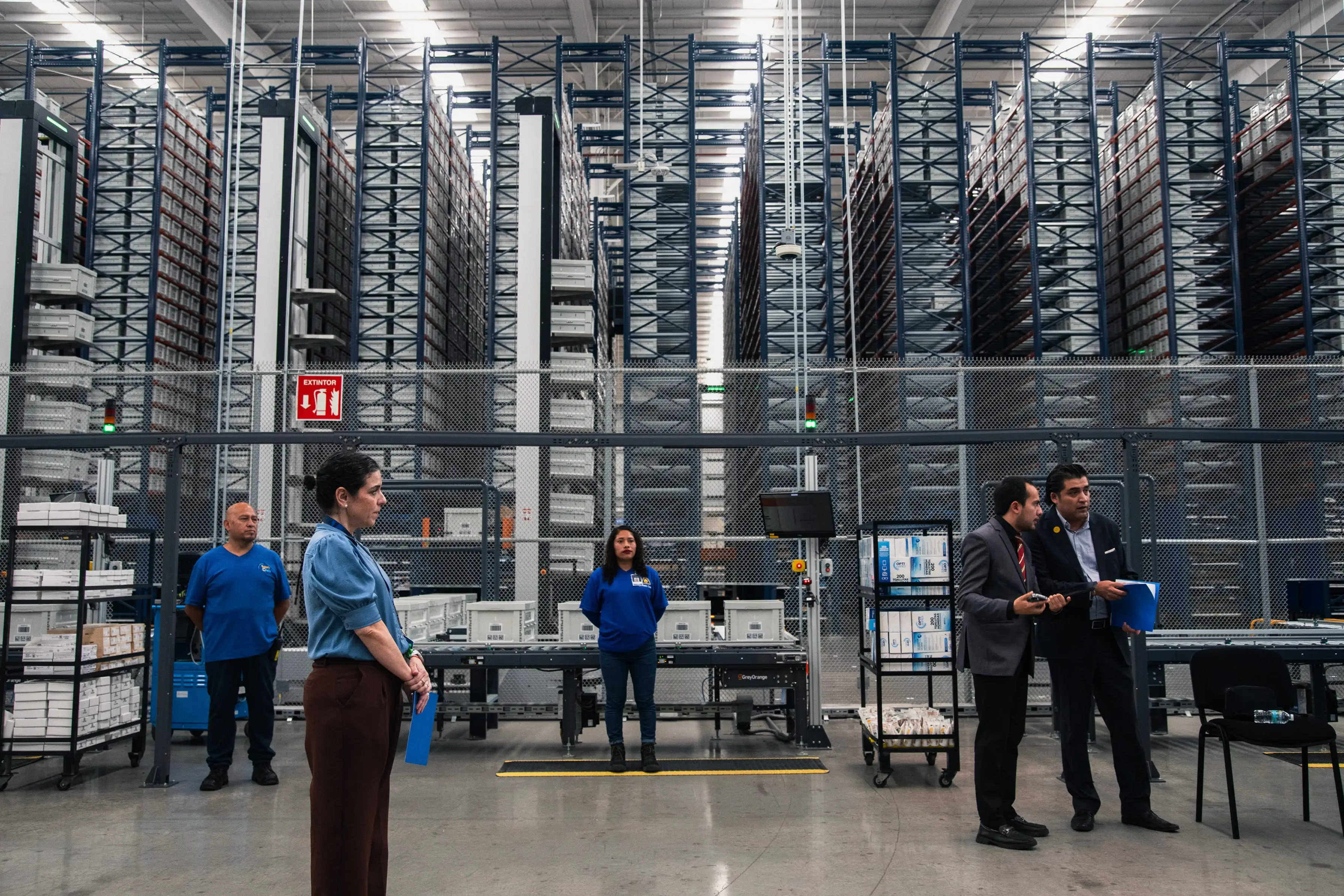Workers in front of shelving equipped with an automated retrieving system at the Wal-Mart de Mexico distribution center megapark in Tepotzotlan, Mexico, on Thursday, May 21, 2026.