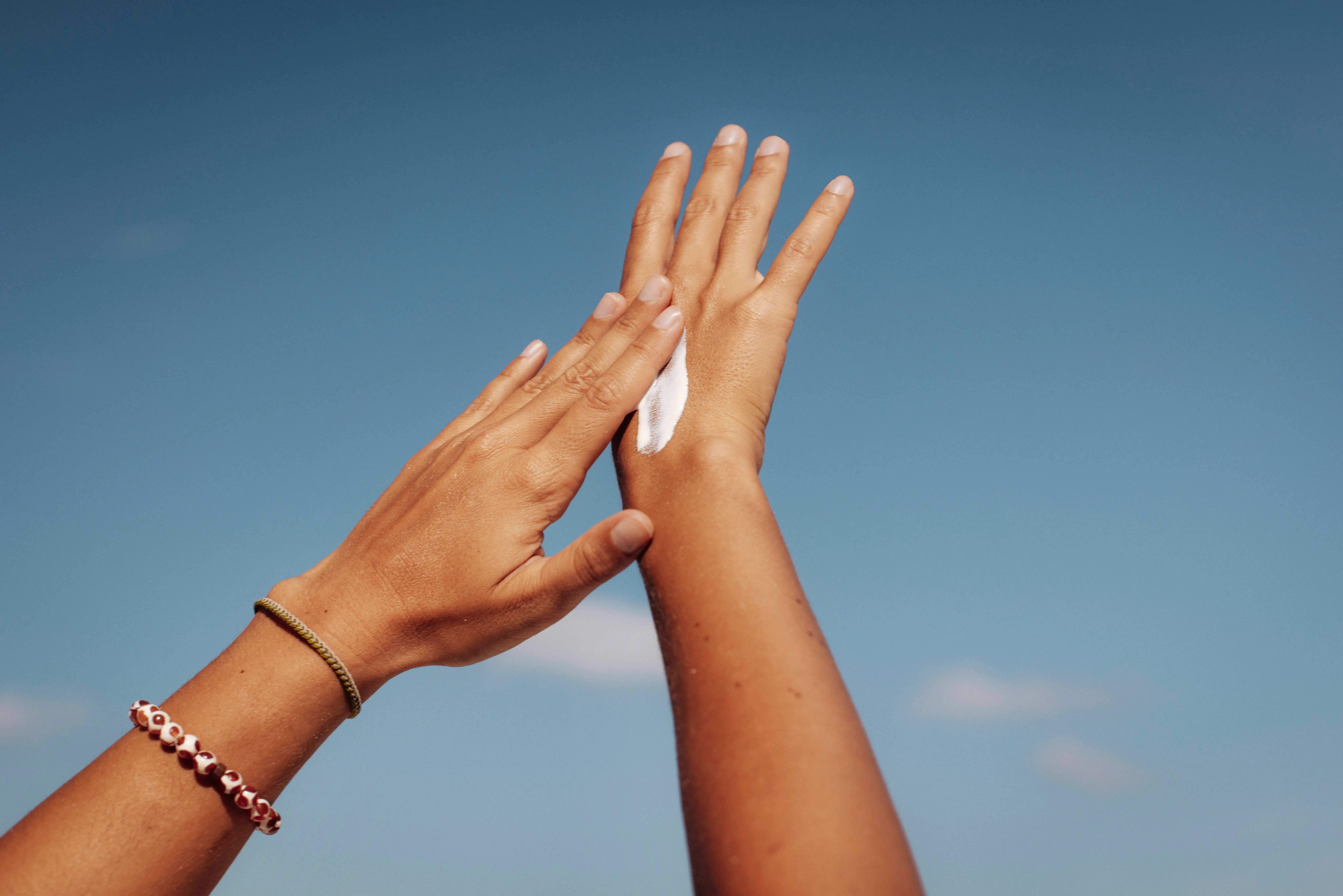 Woman putting sunscreen on hands