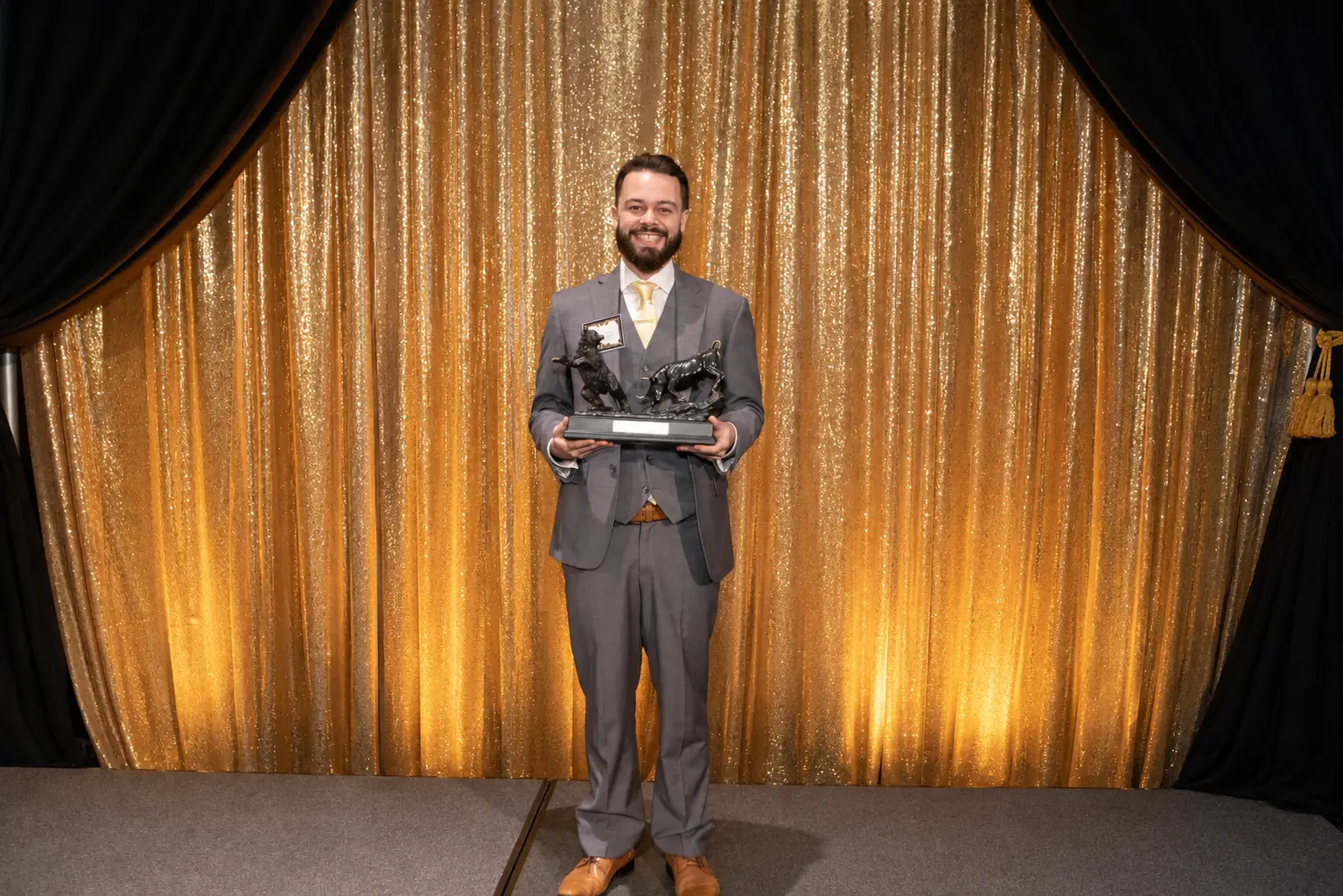 A man holding an award on stage.