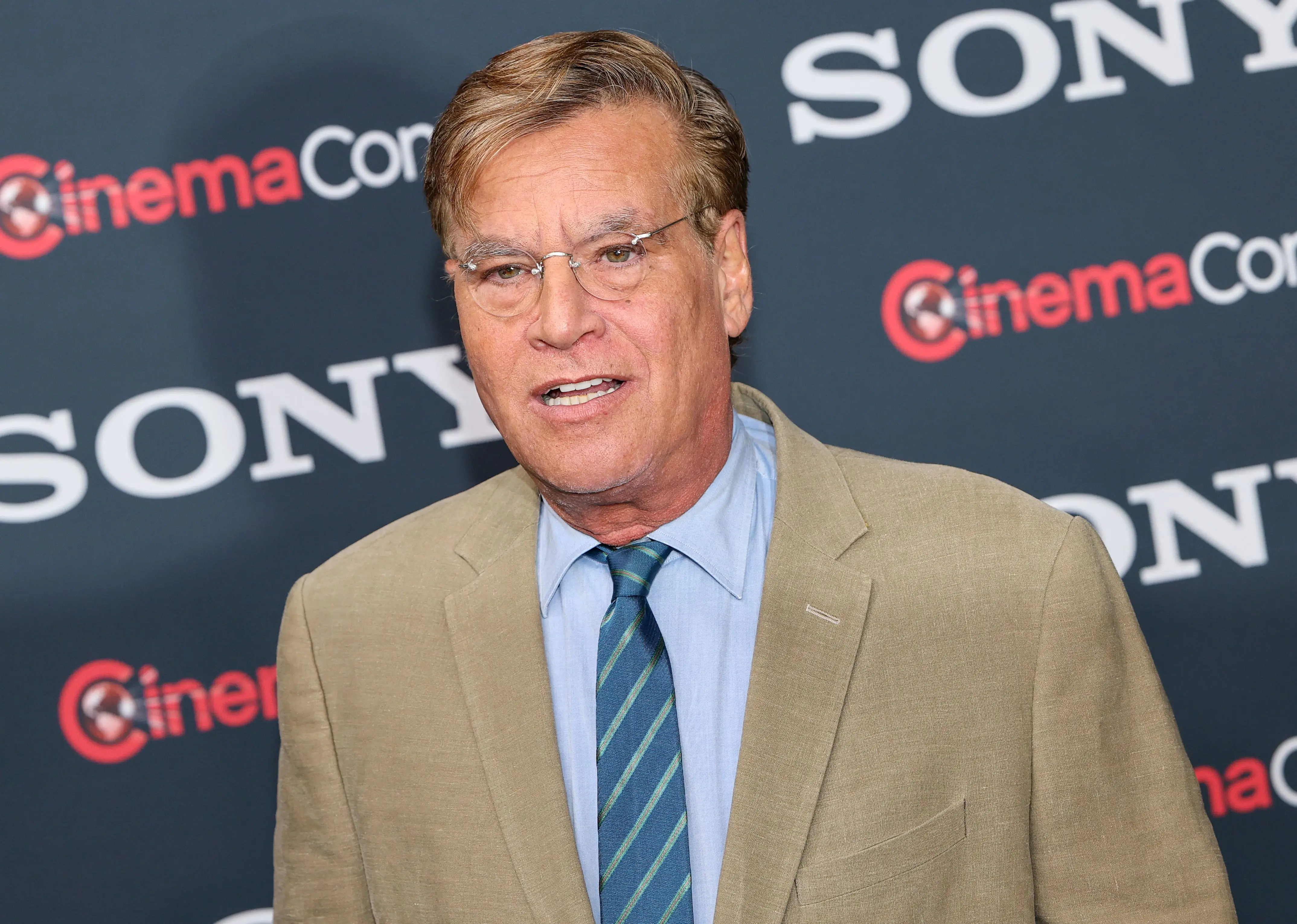 Aaron Sorkin in a cream jacket