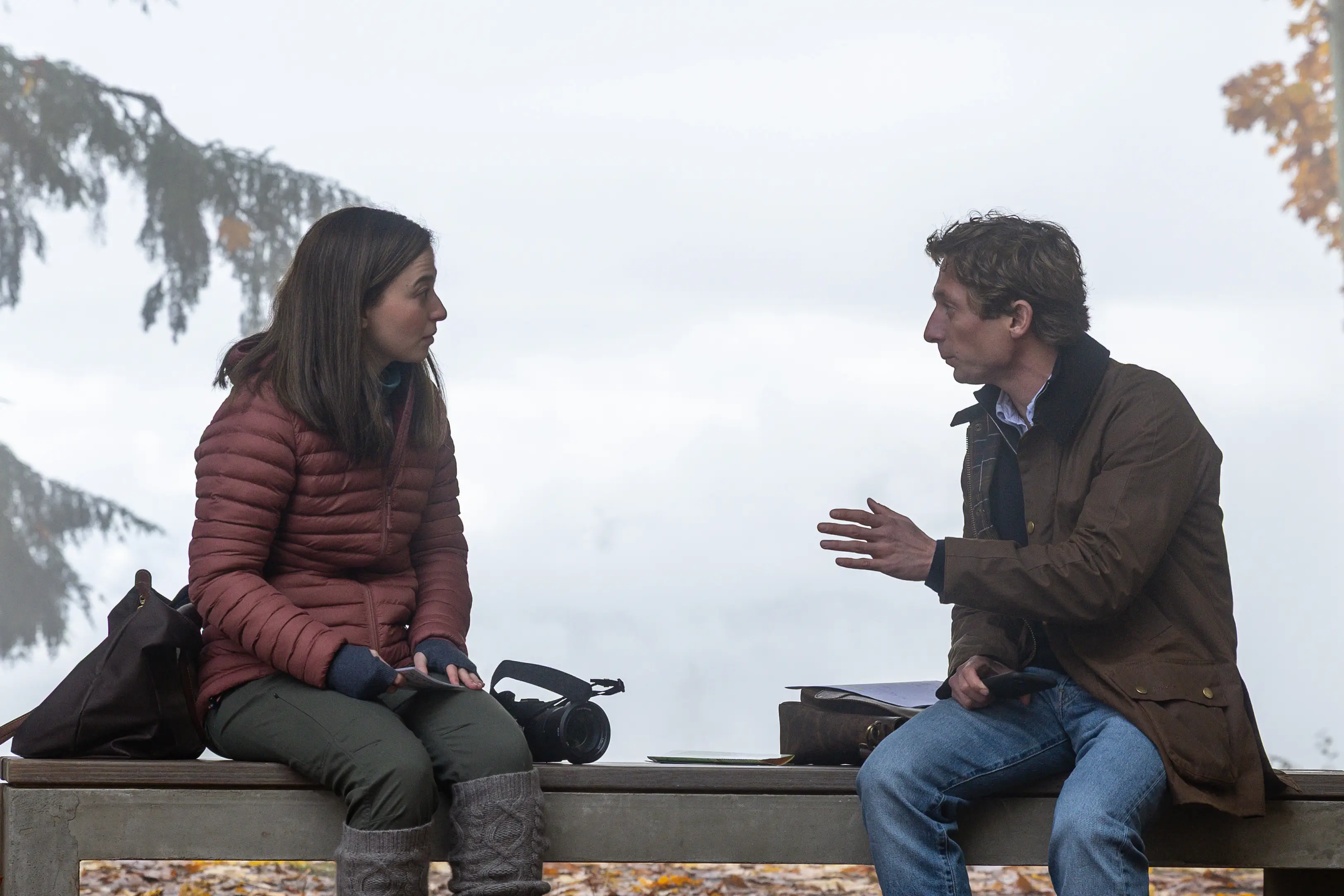 Mikey Madison and Jeremy Allen White sitting on a bench and talking in The Social Reckoning movie