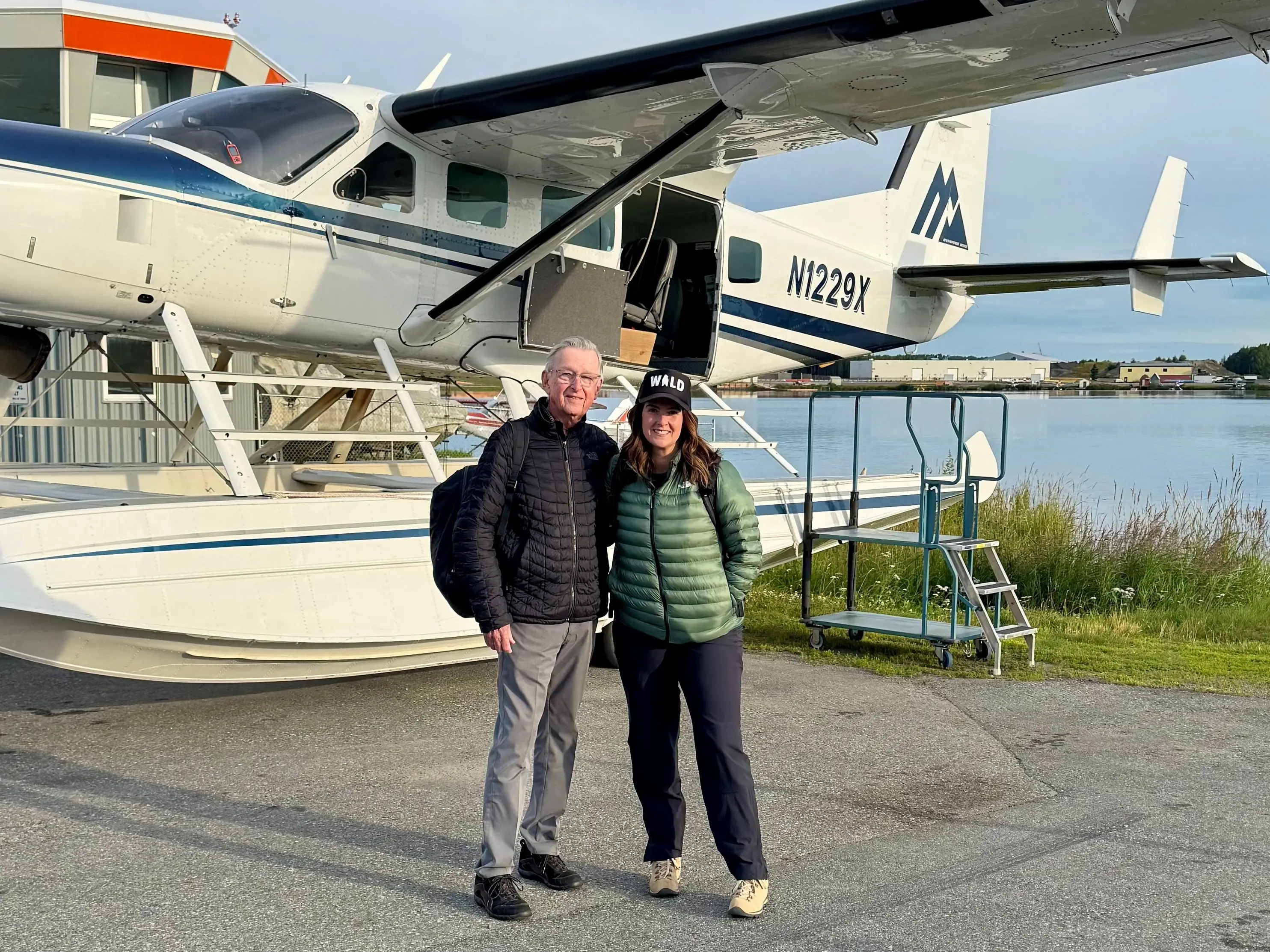 A father and daughter posing in front of a seaplane in remote Alaska.
