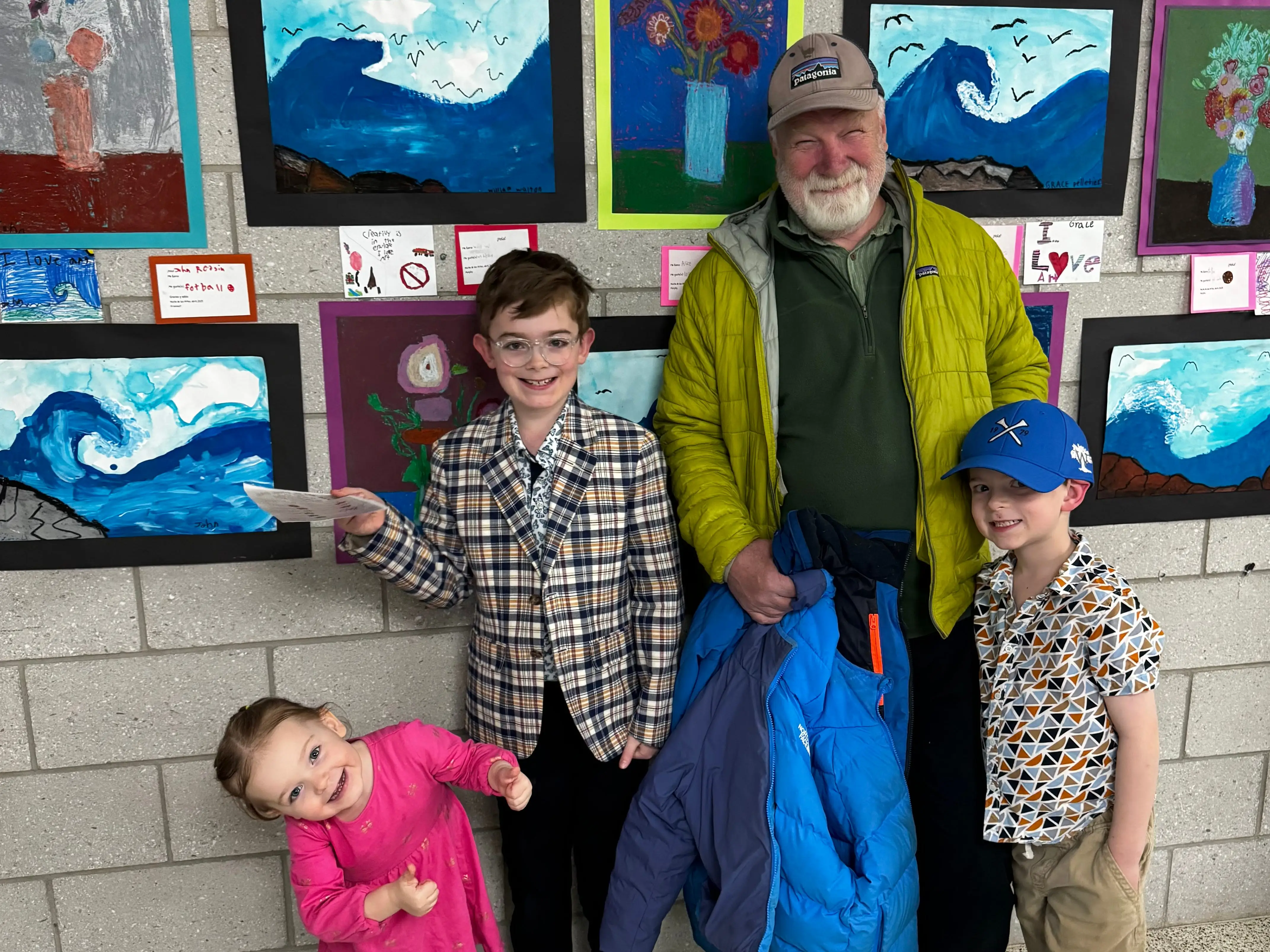 A grandfather with his three grandchildren at an arts fair.