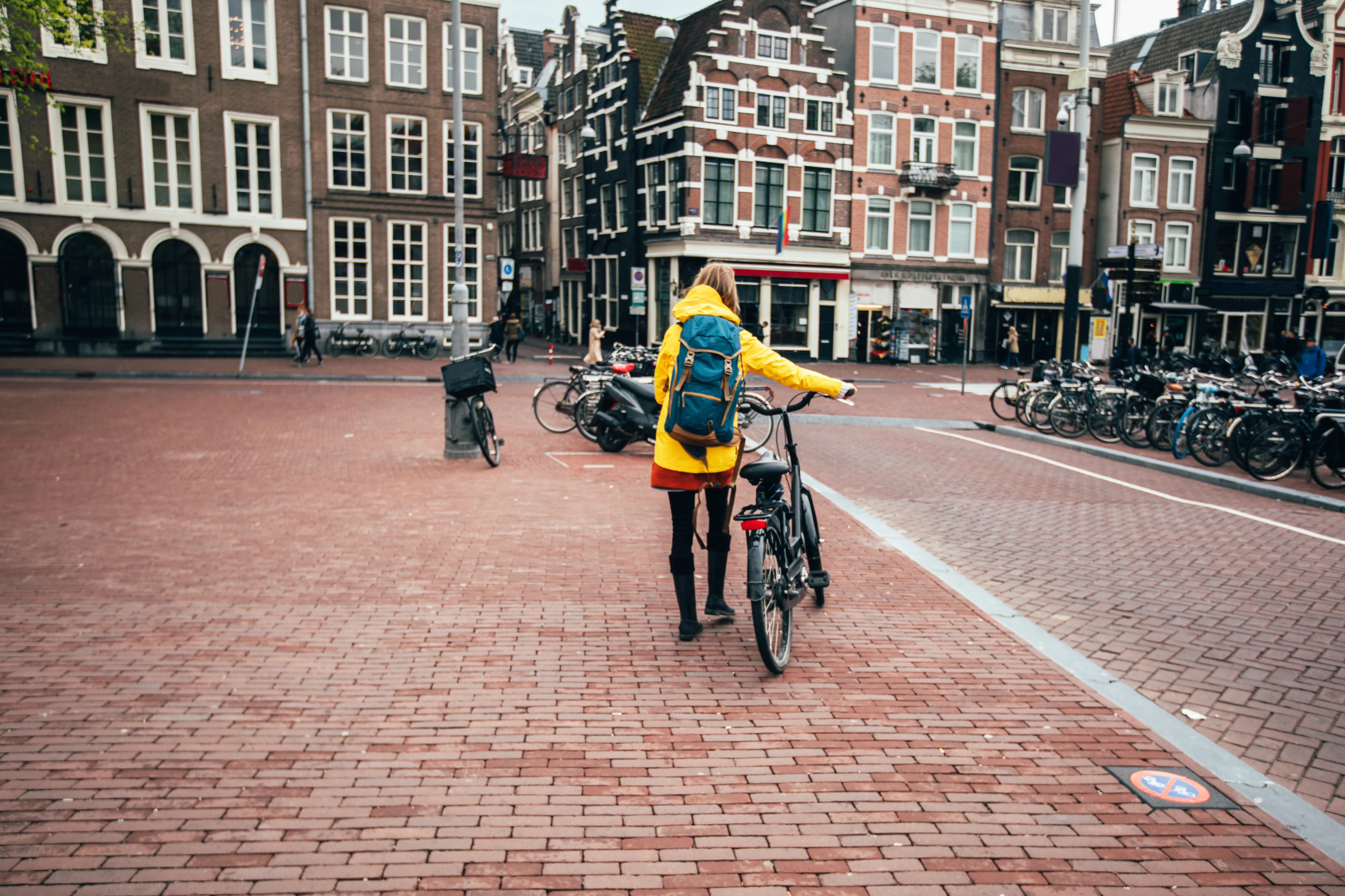 Person with backpack and bike in Amsterdam