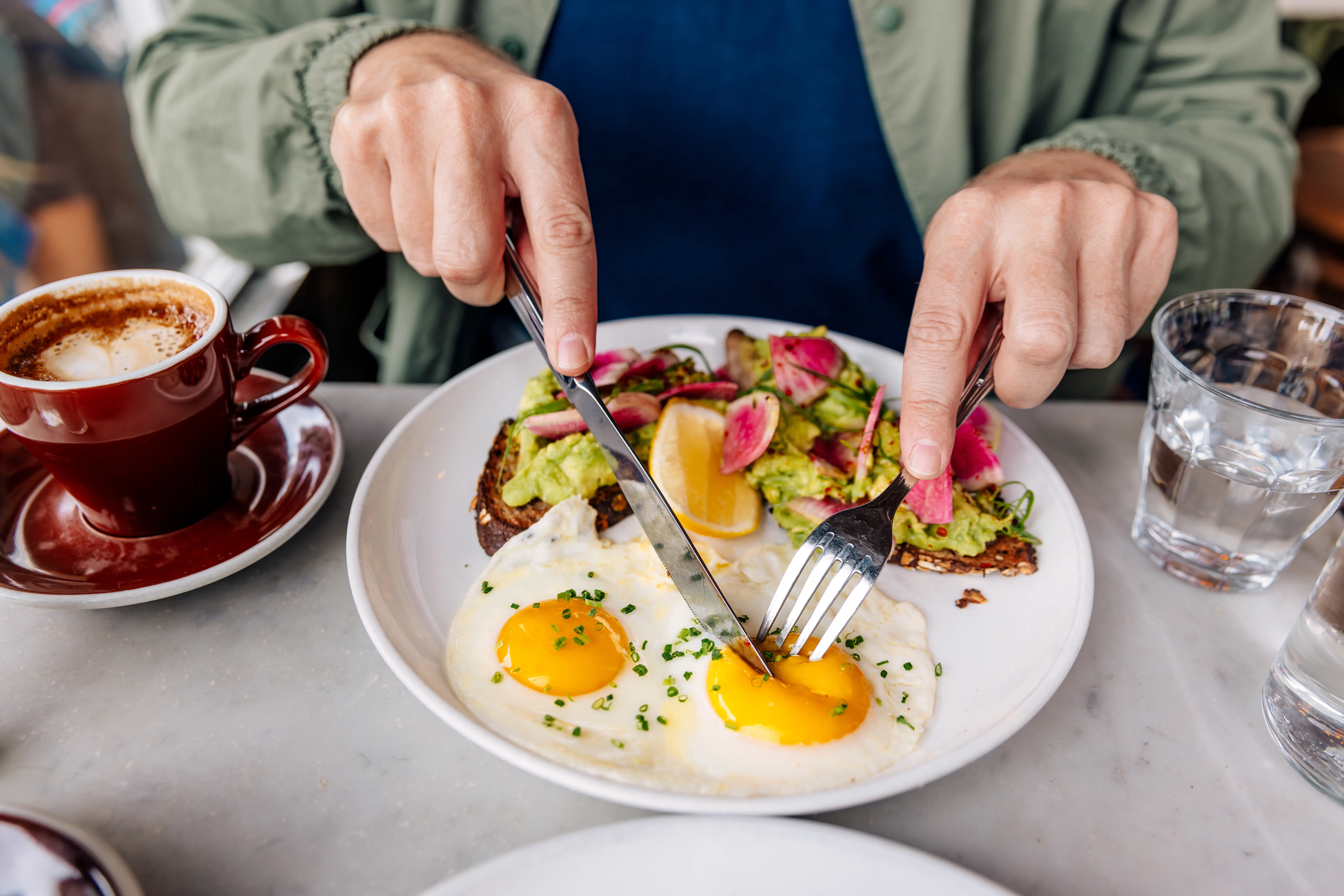 A person eats fried eggs.
