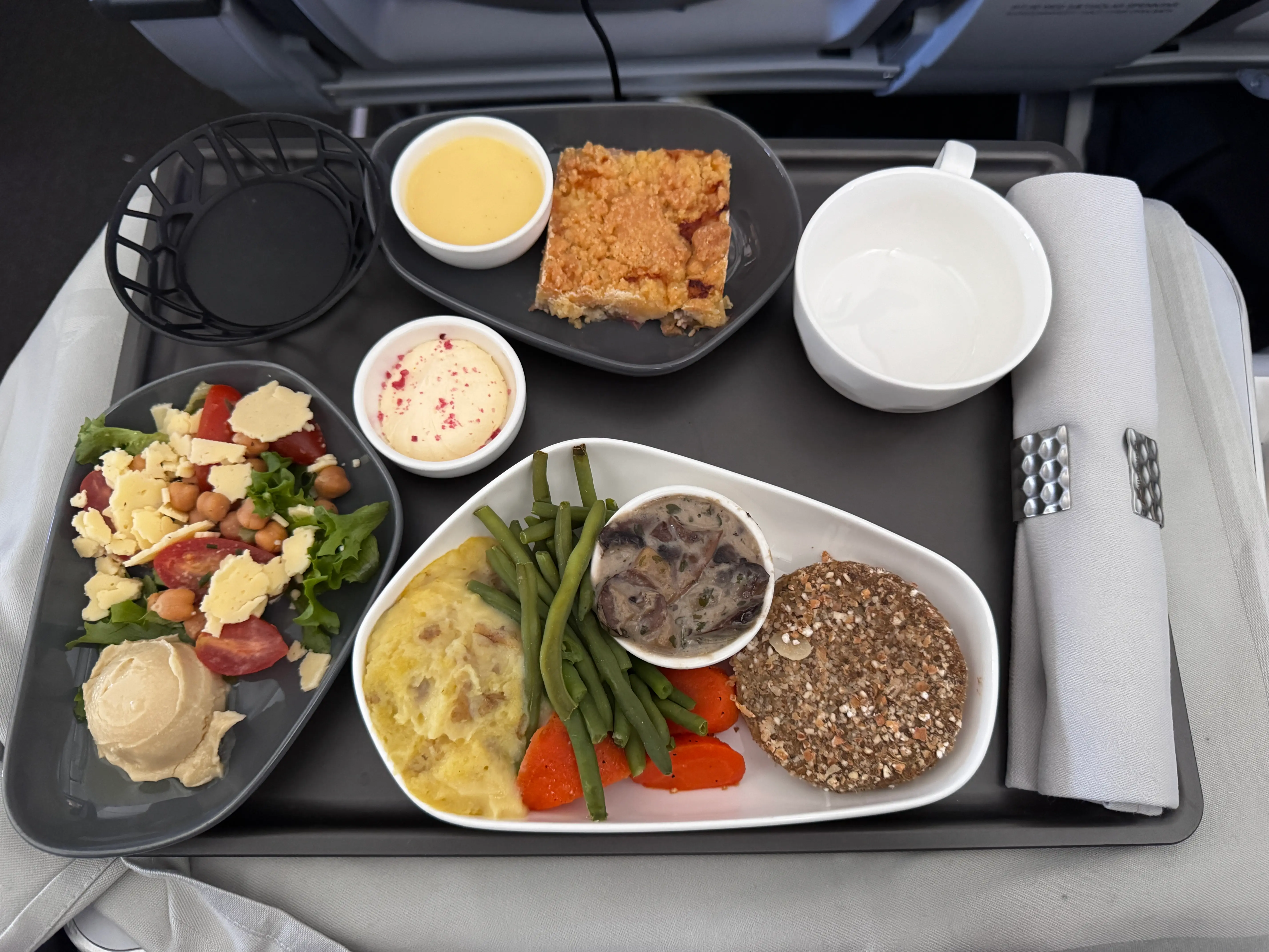 Plates of food on tray table in IcelandAir Saga Premium