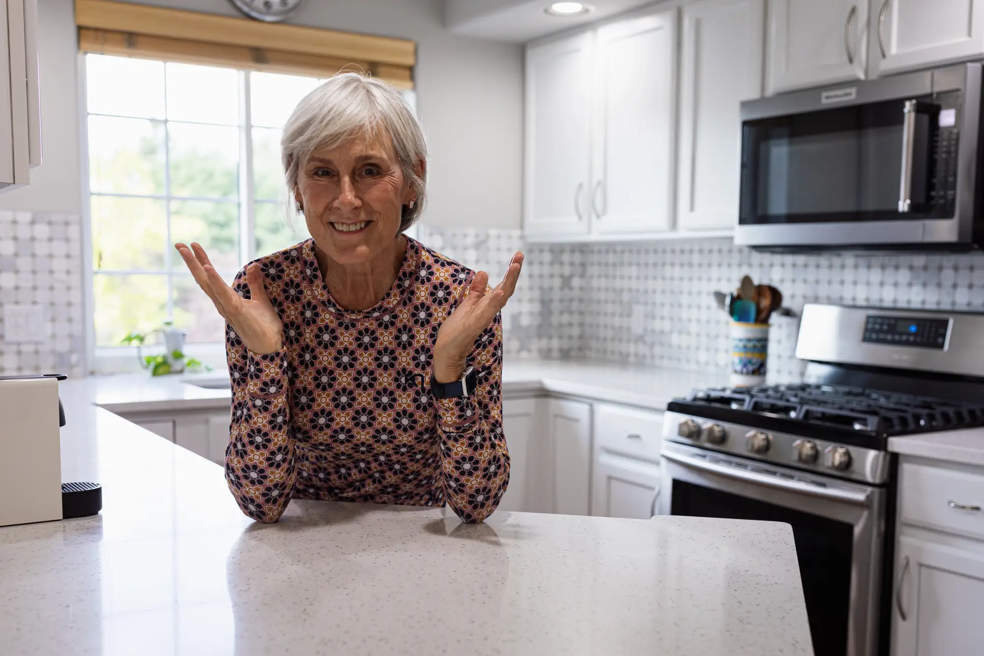 A woman posing in the kitchen of a condo.