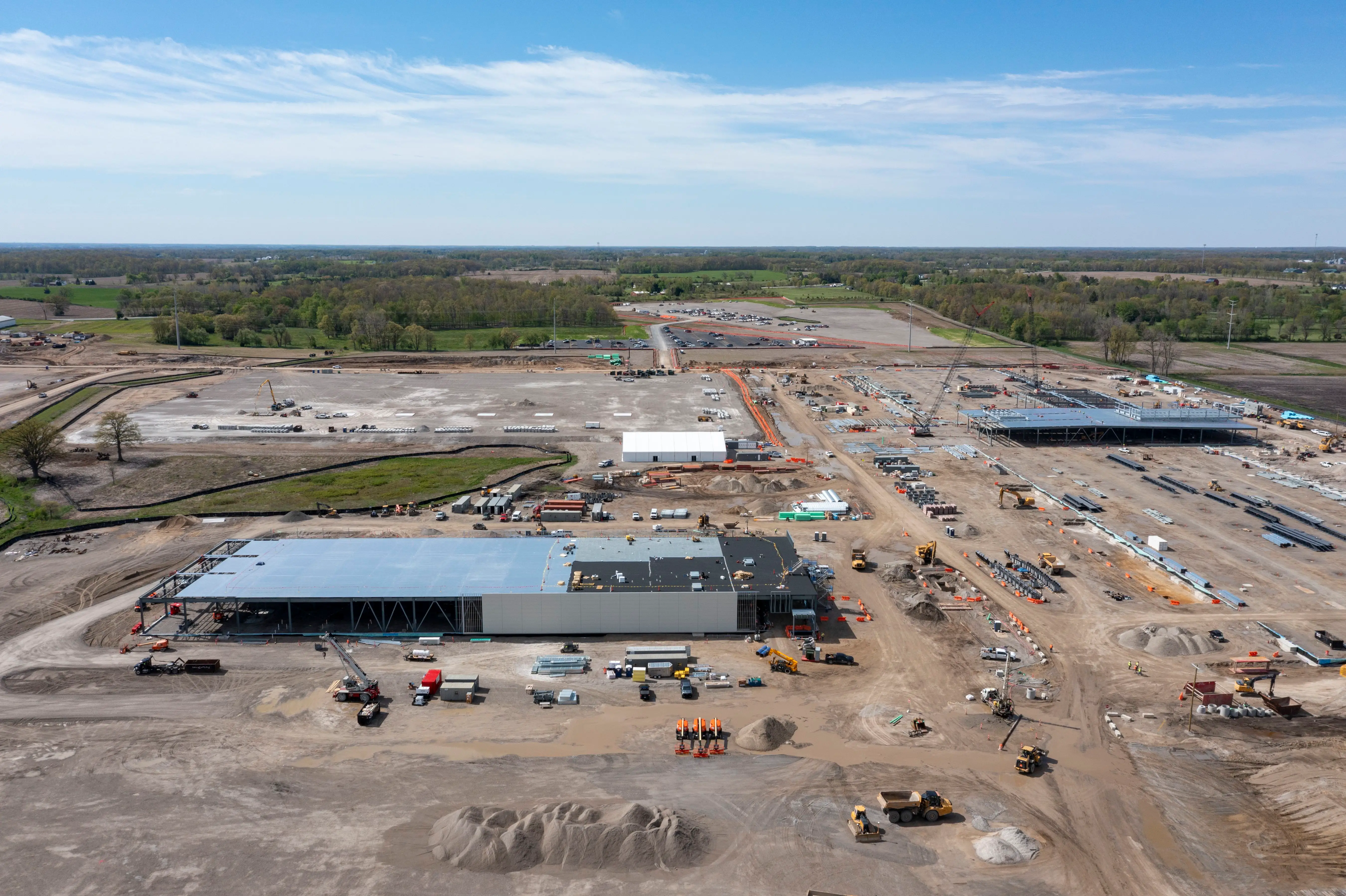 a massive building under construction, surrounded by dirt