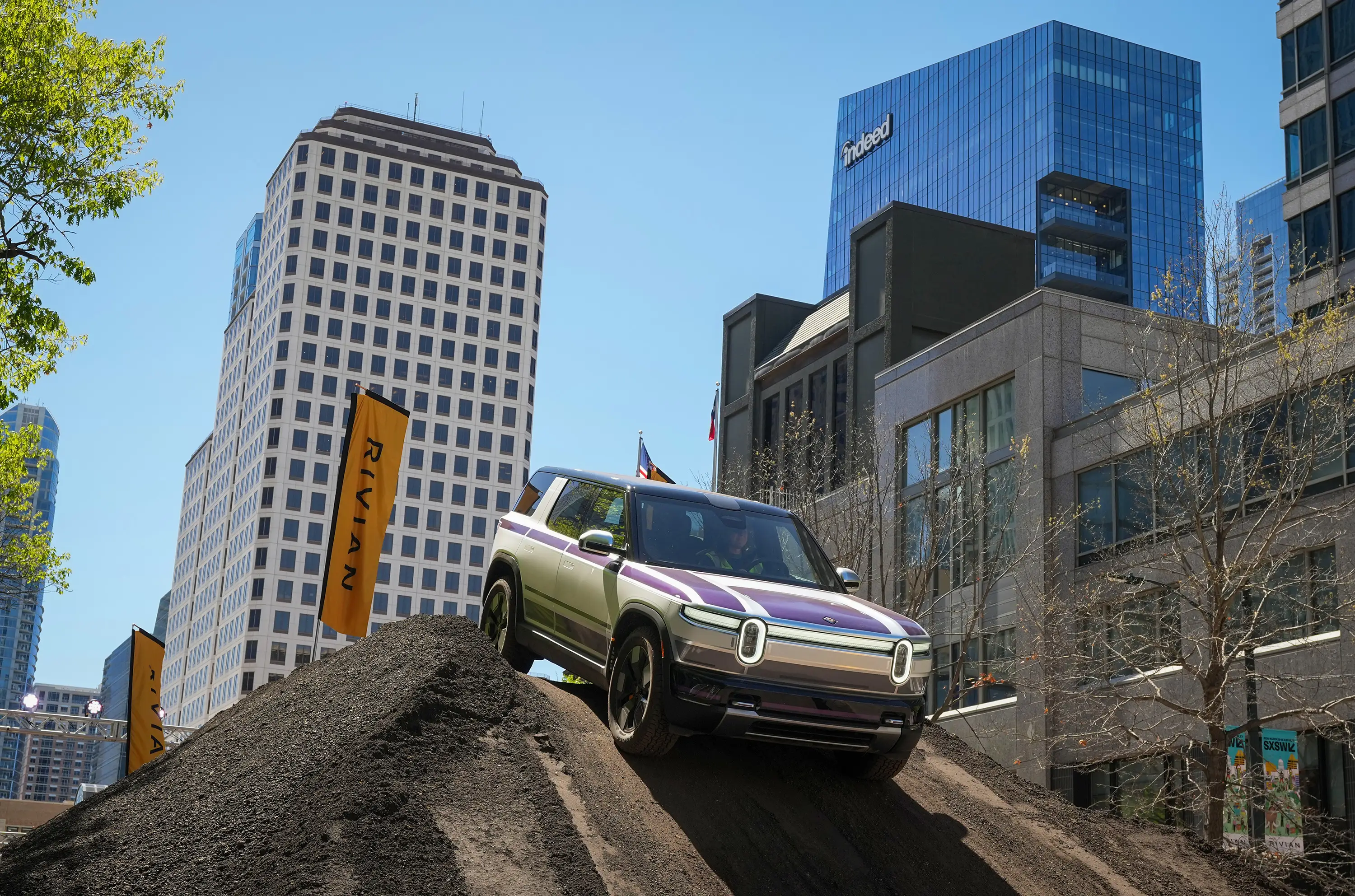 A Rivian R2 electric vehicle drives over a dirt obstacle course set up on Congress Avenue during the South by Southwest Conference and Festivals in Austin on Thursday, March 12, 2026.