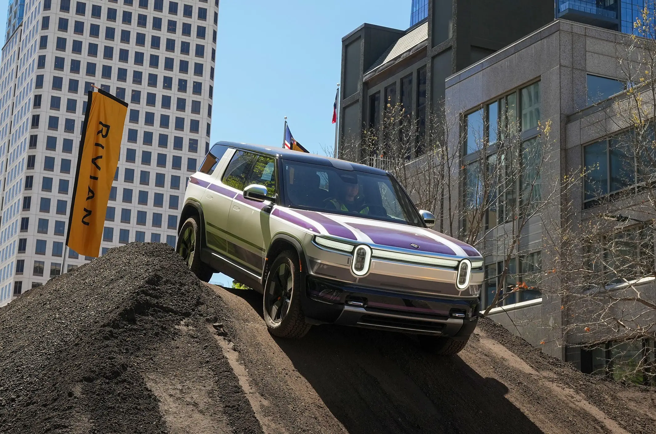 A Rivian R2 electric vehicle drives over a dirt obstacle course set up on Congress Avenue during the South by Southwest Conference and Festivals in Austin on Thursday, March 12, 2026.