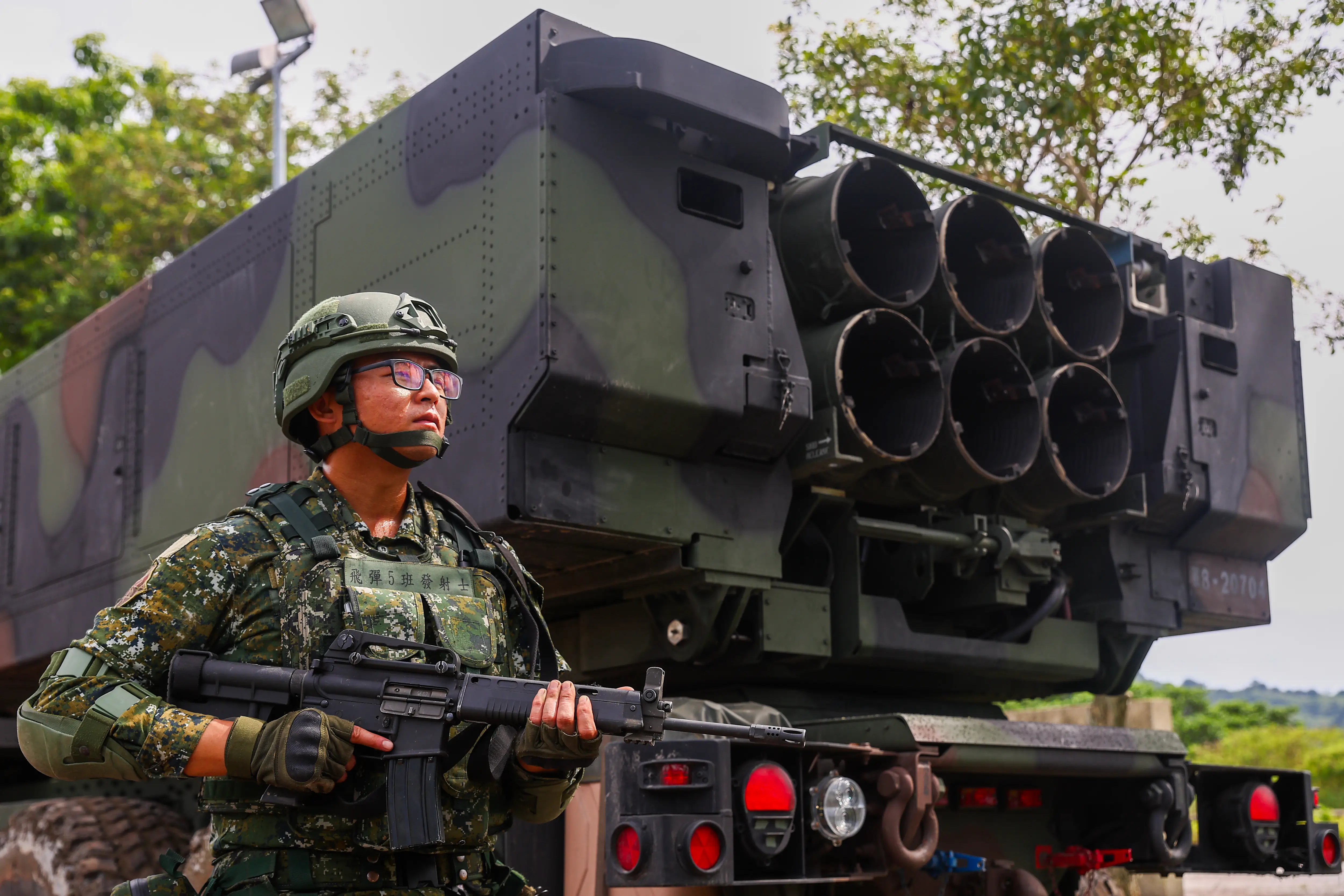 A Taiwanese soldier stands next to a HIMARS launcher.