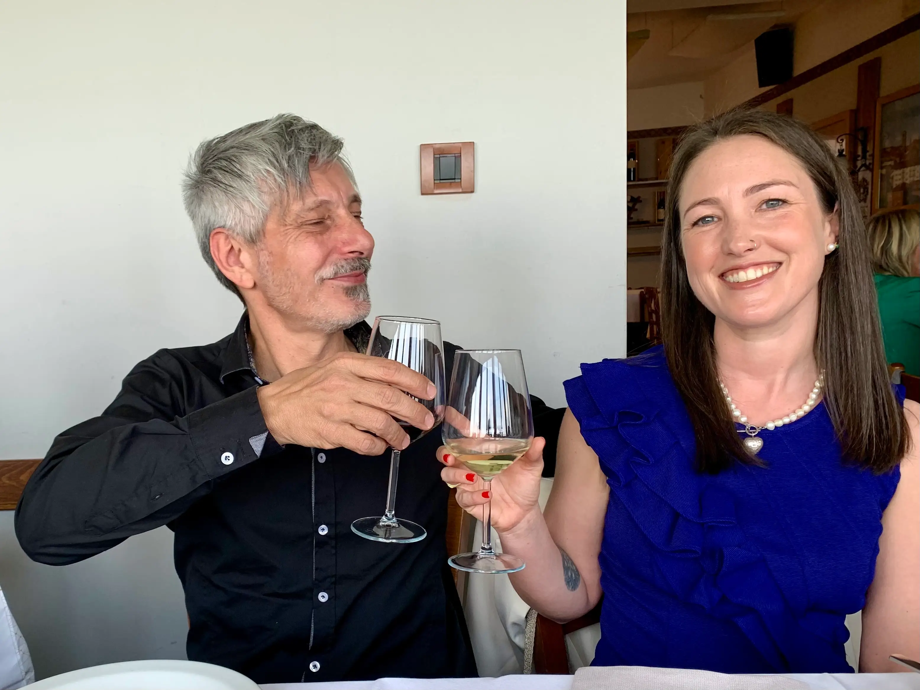 The author and her partner clink wine glasses.