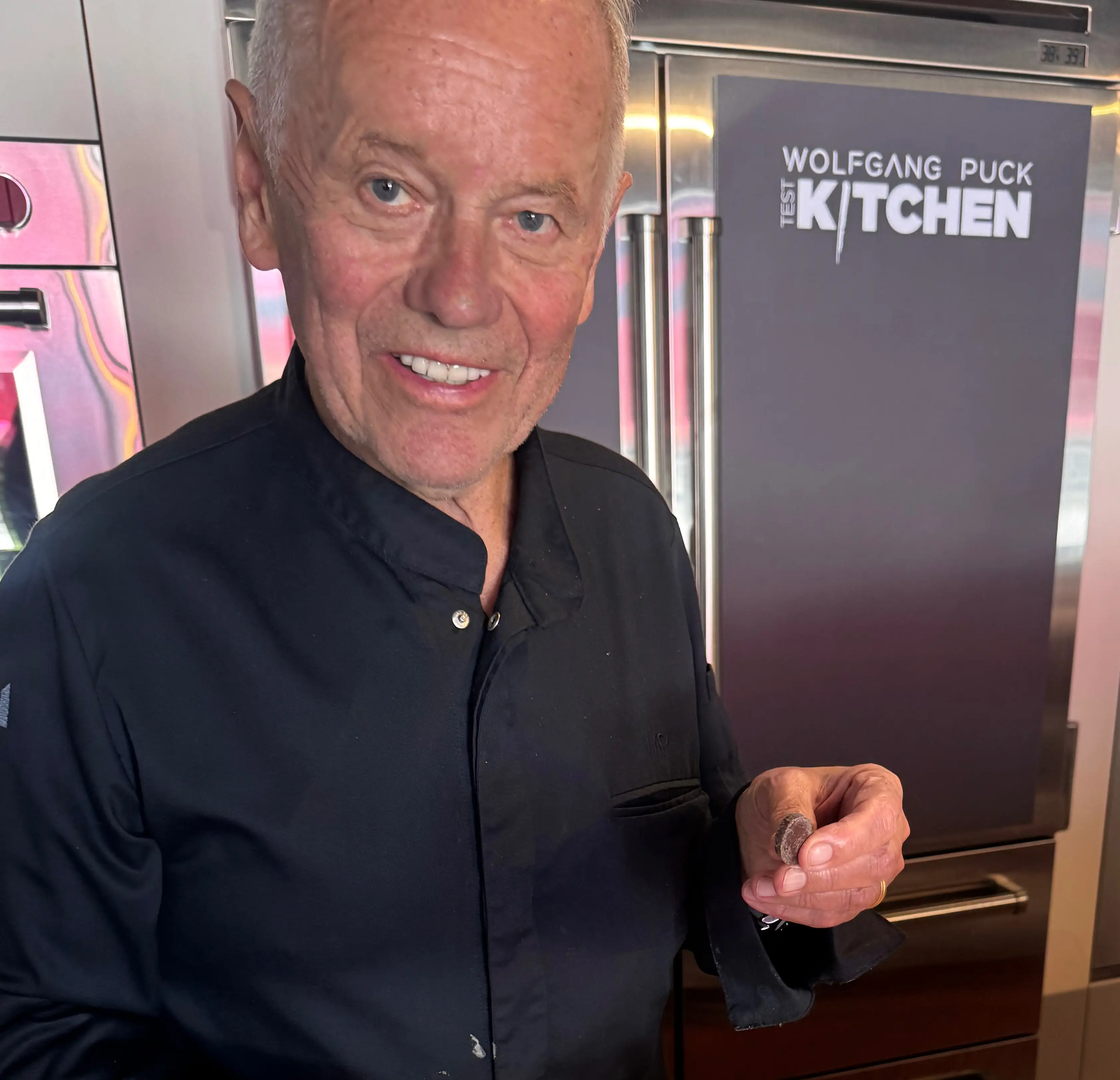 Chef Puck holding a piece of dark chocolate.