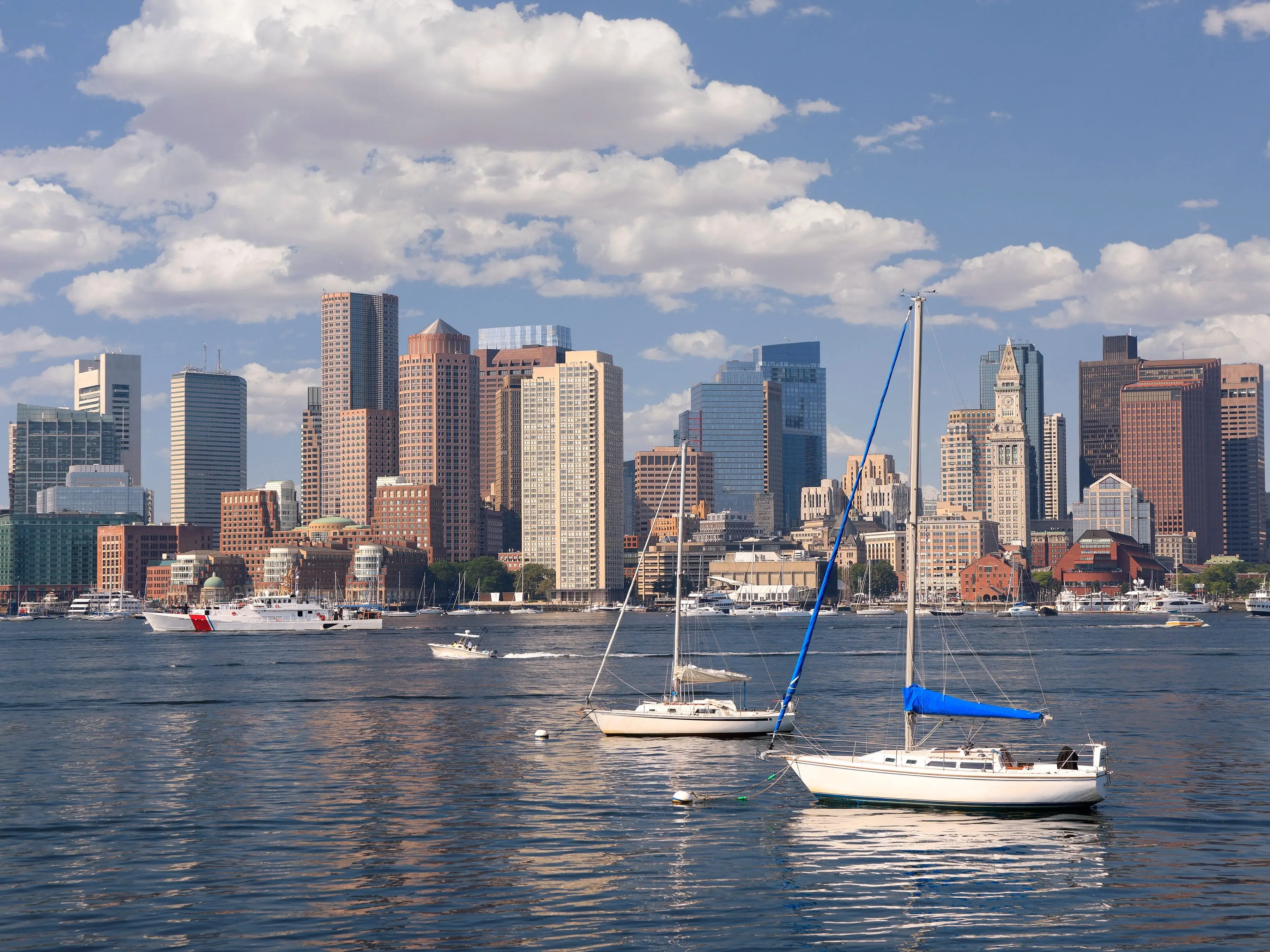Boats on water in front of Boston, Massachusetts, skyline