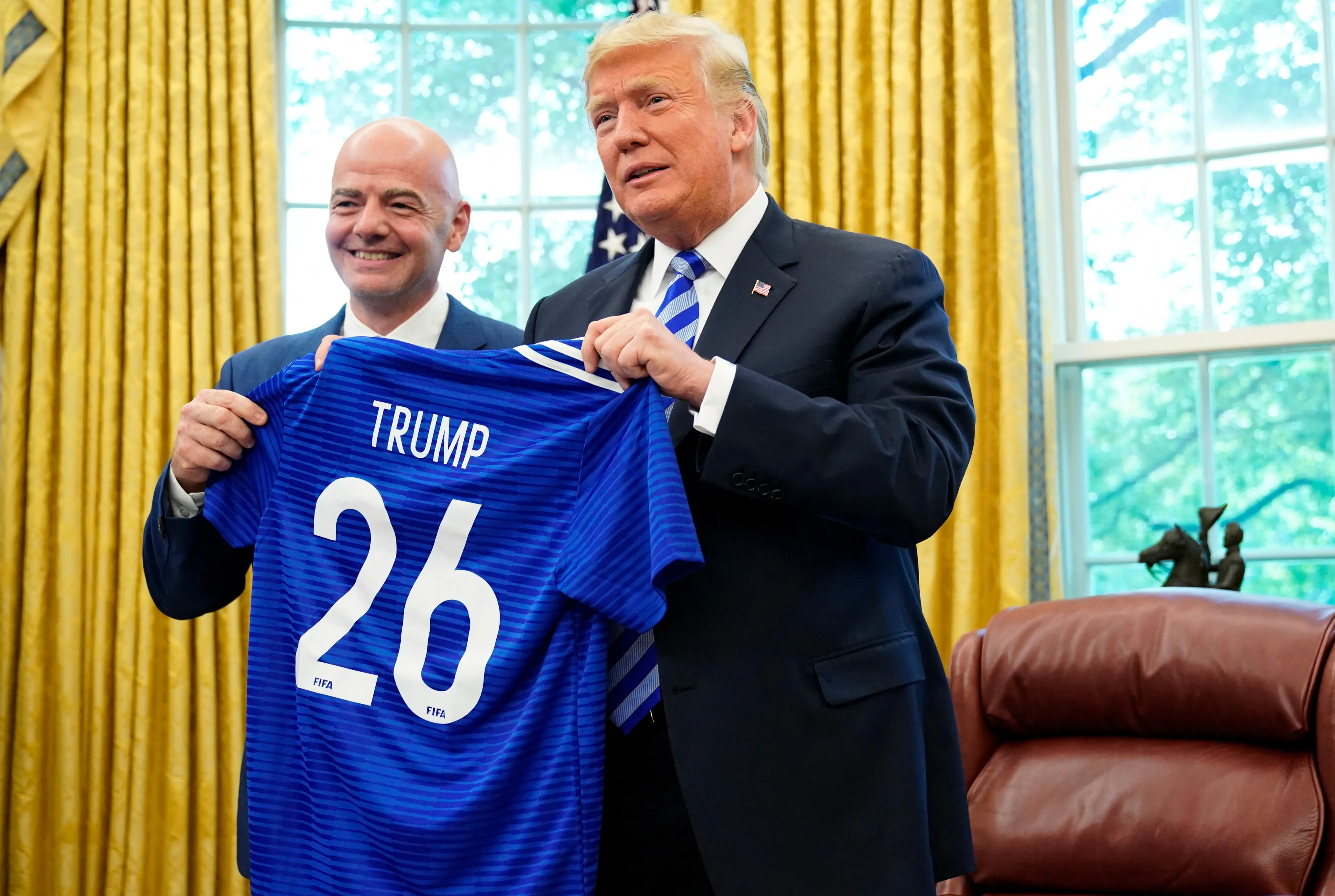 President Donald Trump and FIFA President Gianni Infantino pose with a jersey presented to Trump by Infantino on August 28, 2018.