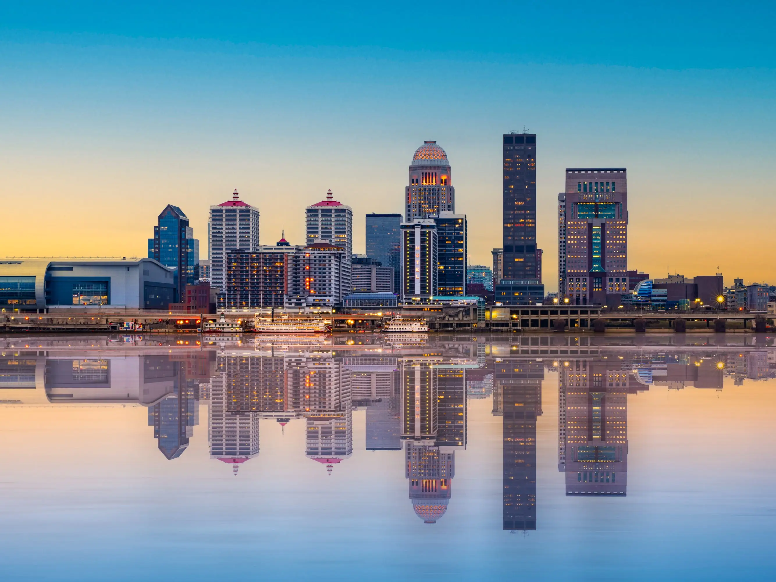Beautiful sunset night view of Louisville Kentucky Skyline with river and lit buildings