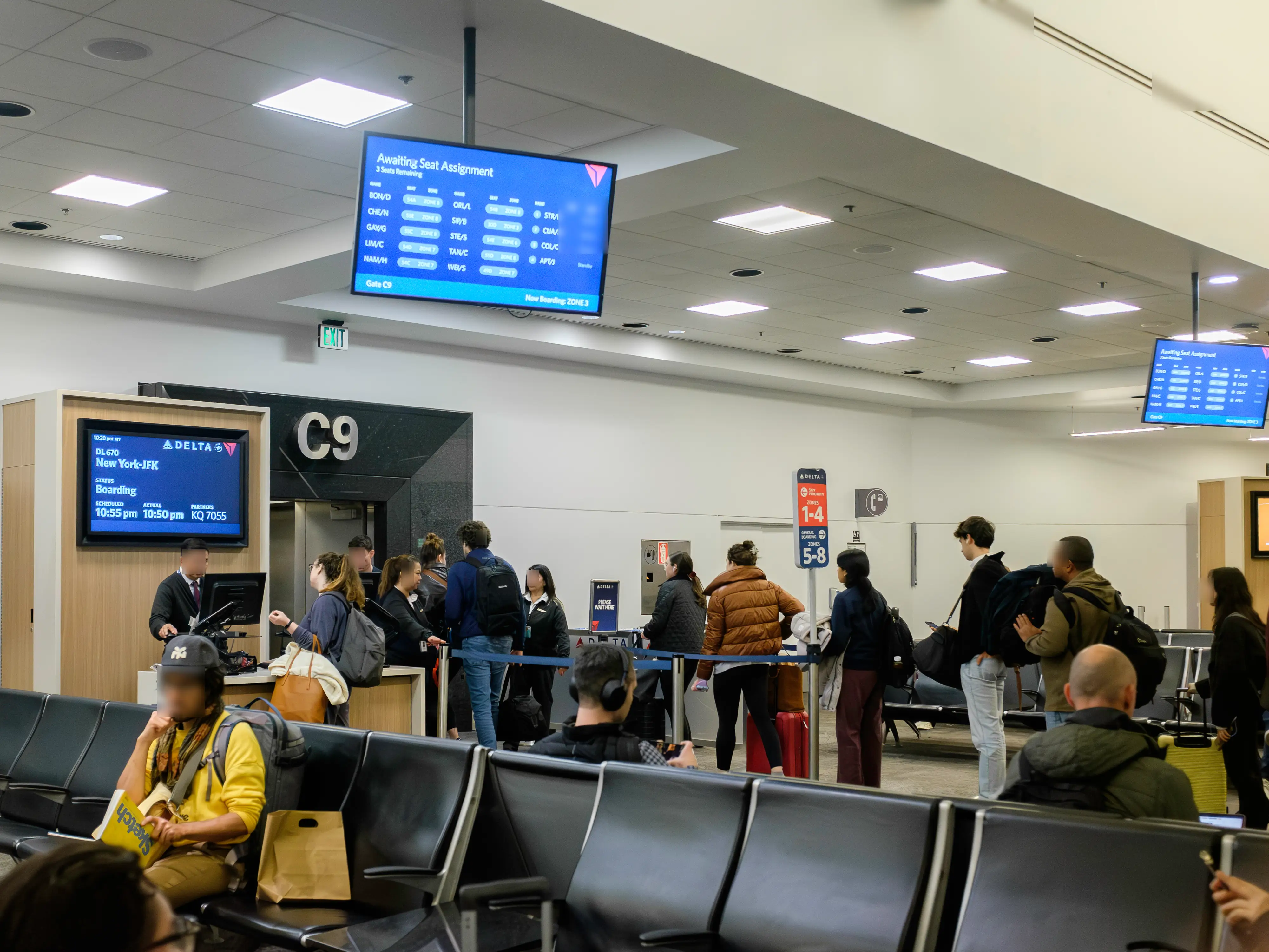 Passengers wait in line to board at a Delta gate.